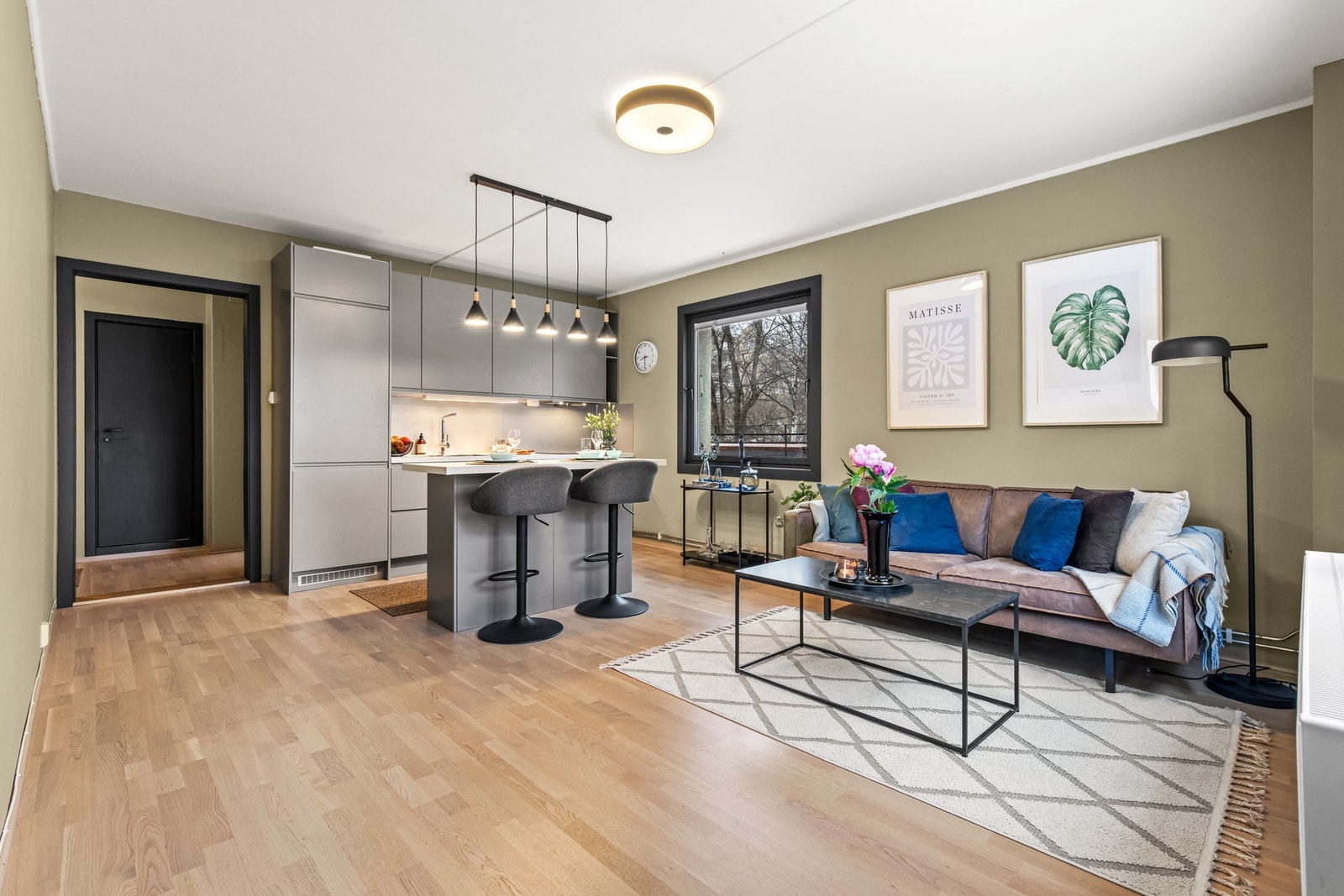 Romslig og lekker stue med parkett på gulv og moderne fargevalg. Galleribilde