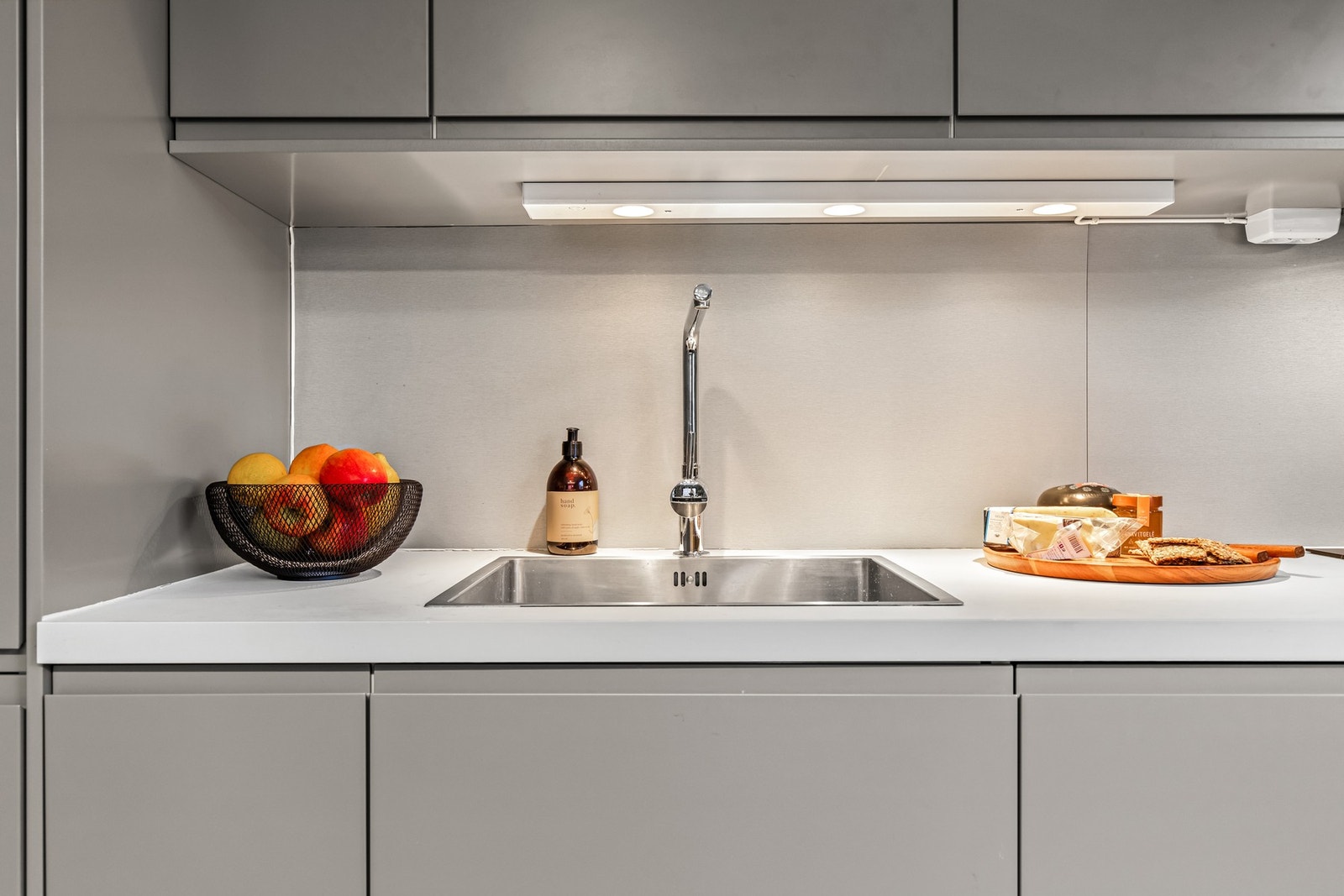 Gjennomført kjøkken med laminert benkeplate og nedfelt oppvaskkum. Galleribilde