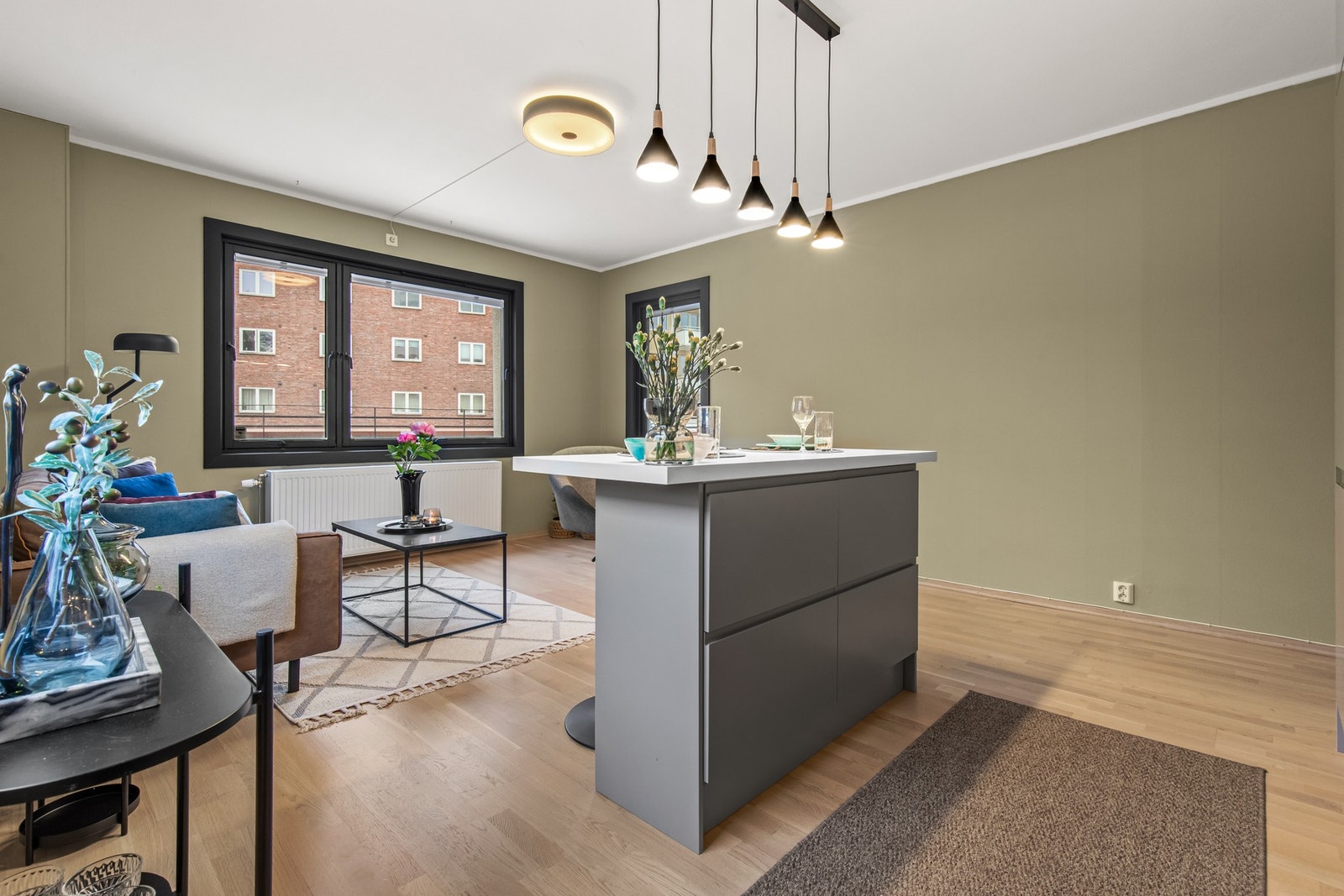 Stilrent kjøkken fra 2020 med kjøkkenøy og hyggelig overgang mot stue. Galleribilde