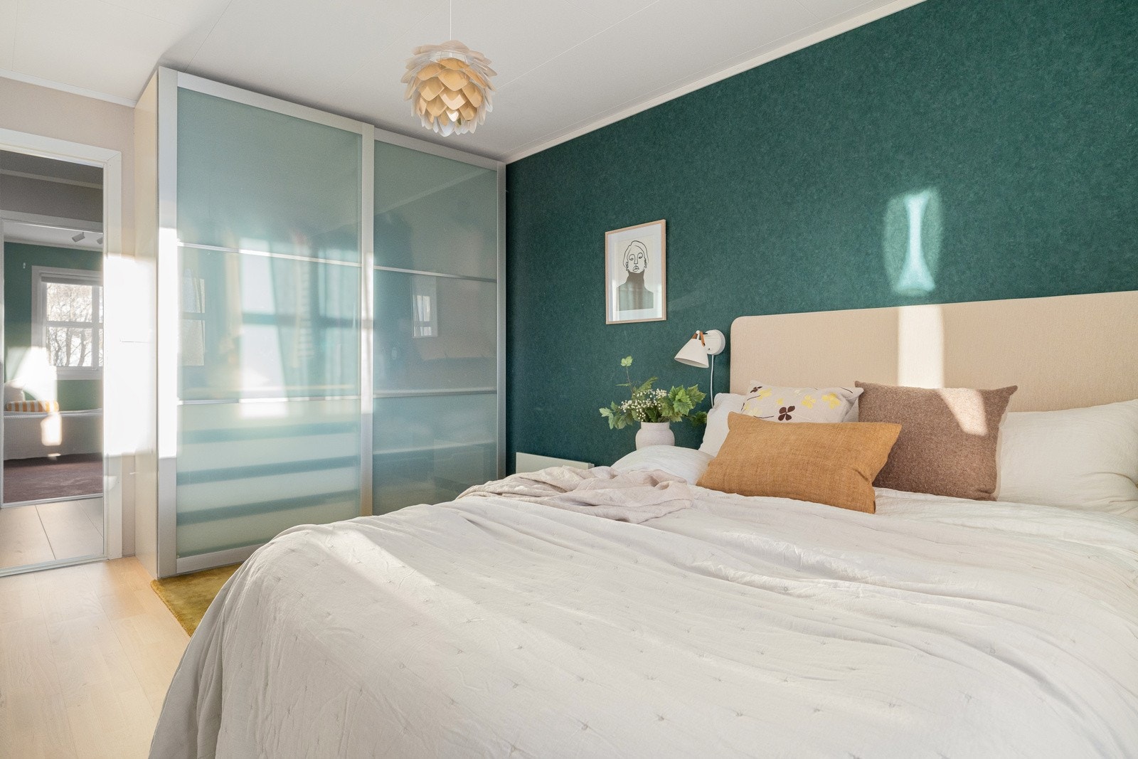 Rommet har skyvedørsgarderboe og plass til stor seng med tilhørende nattbord.