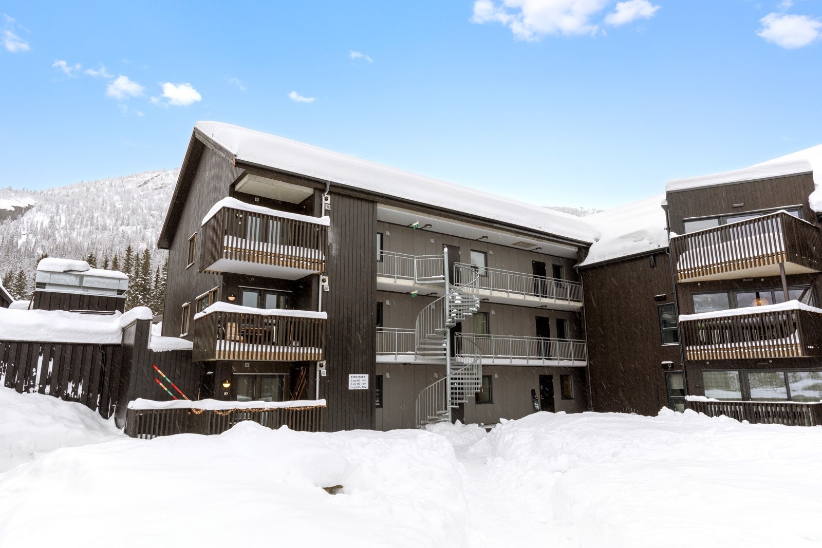 Svalgang med vindeltrapp ned til tunet. Inngangsdør utenfra Galleribilde