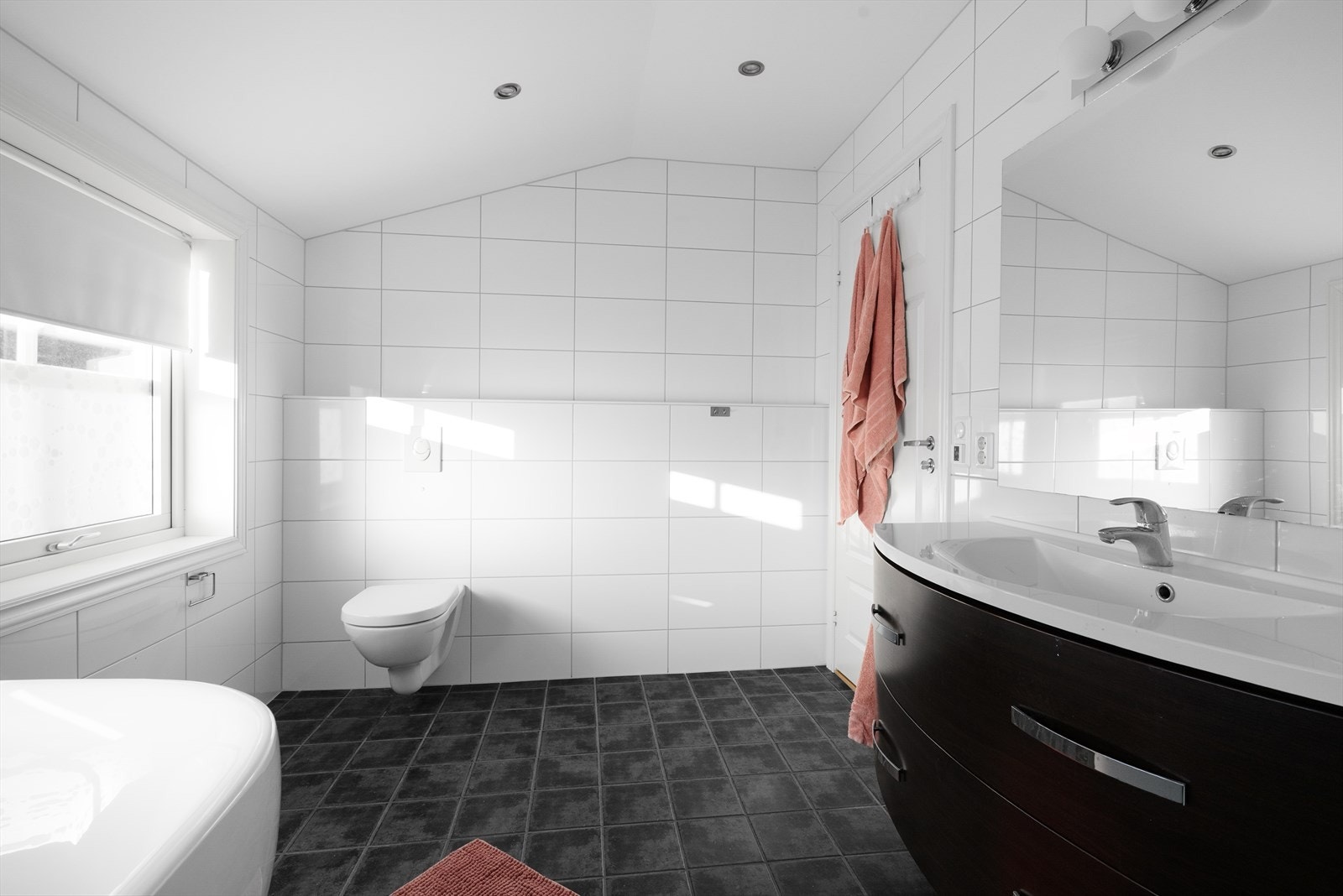 Delikat baderom med flis på gulv, flis på vegg og malt himling med spotter. Galleribilde