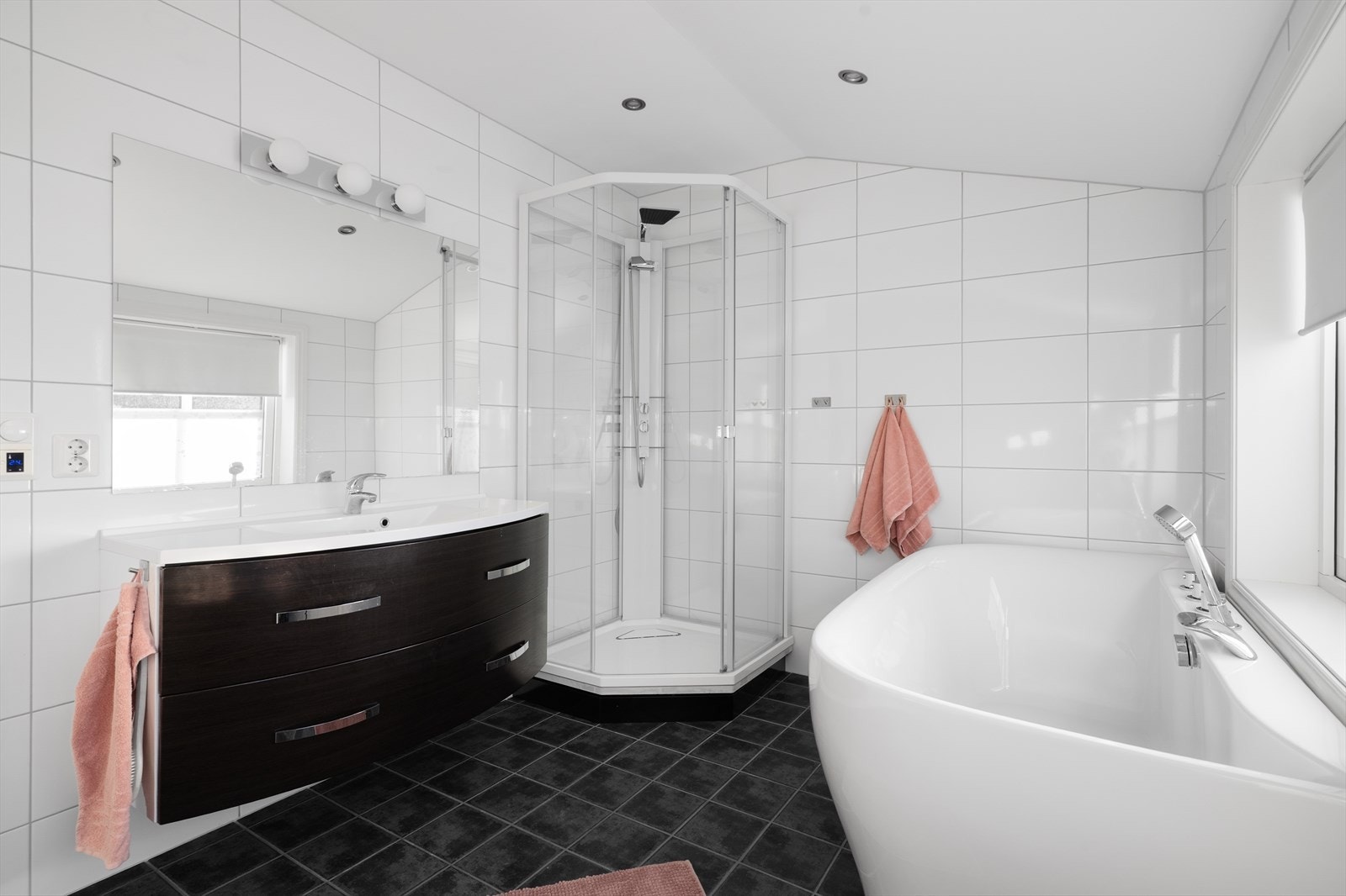 Rommet inneholder heldekkende servant med underskap, speil med lys over, vegghengt toalett, badekar og dusjkabinett. Galleribilde