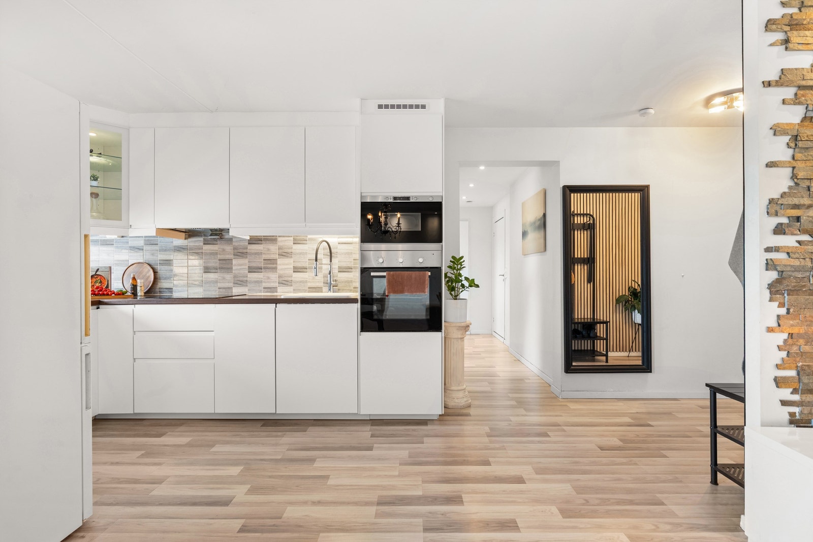 Lyst og pent kjøkken med tidløs innredning i lyse, slette flater i åpen løsning til stue. Nye kjøkkenfronter i 2025. Galleribilde