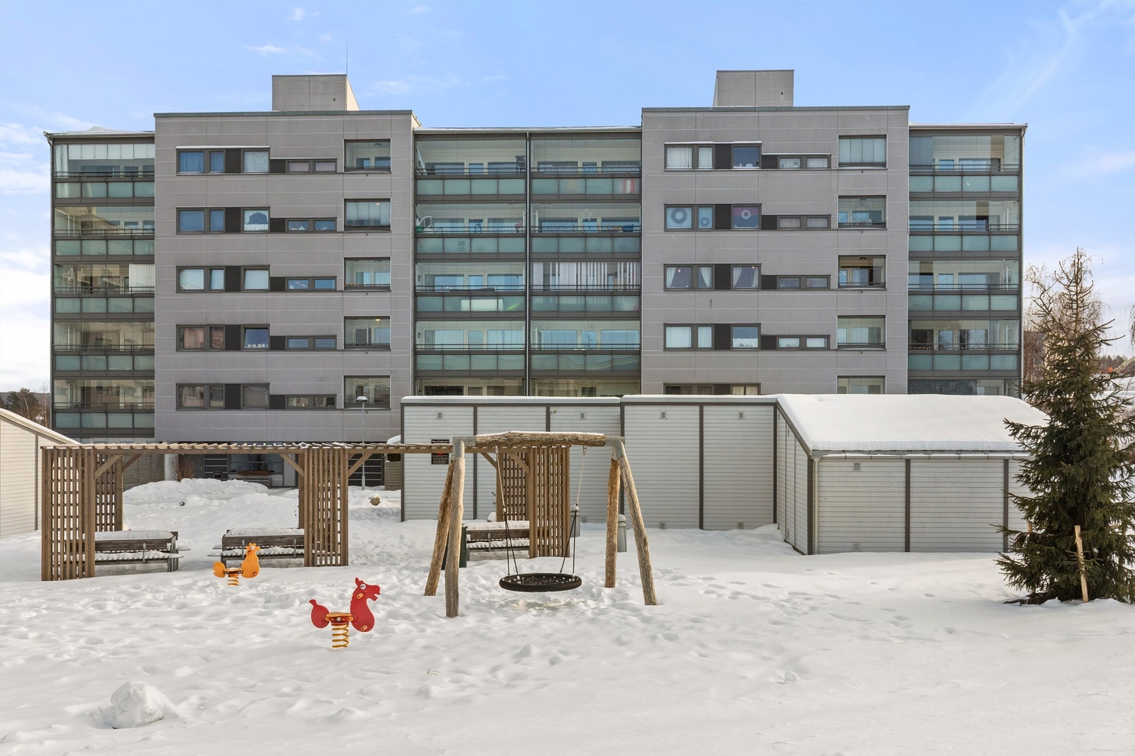 Pent opparbeidet tomt med diverse lekeapparater og grøntområder. Galleribilde