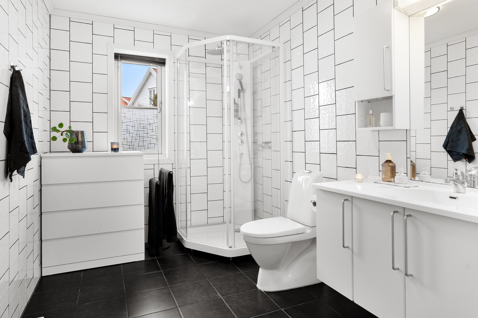 Flott, helfliset bad i 1. etasje med mørke gulv fliser, varmekabler og hvite fliser på vegg. Galleribilde