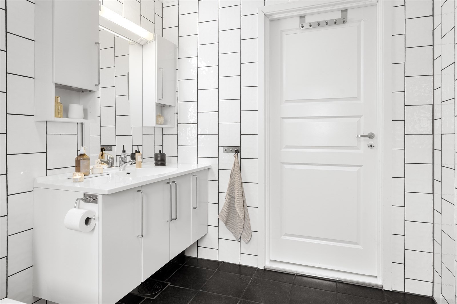 Badet har hvit baderomsinnerdning, speil på veg, dusjkabinett og toalett. Galleribilde