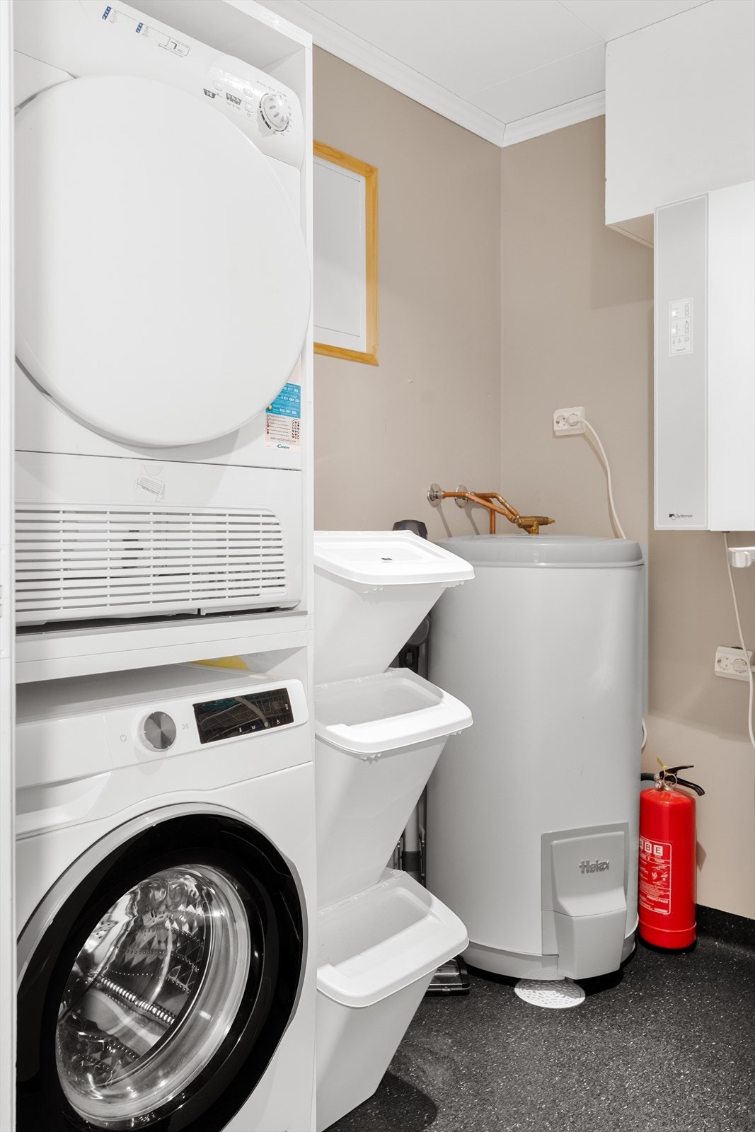 Vaskerom med belegg på gulv og malte vegger. I rommet er anlegget for den balanserte ventilasjonen, rørskapet, varmtvannstank som ble satt inn i 2021 (Produsert i 2018), opplegg for vaskemaskin og plass til tørketrommel i rommet. Galleribilde