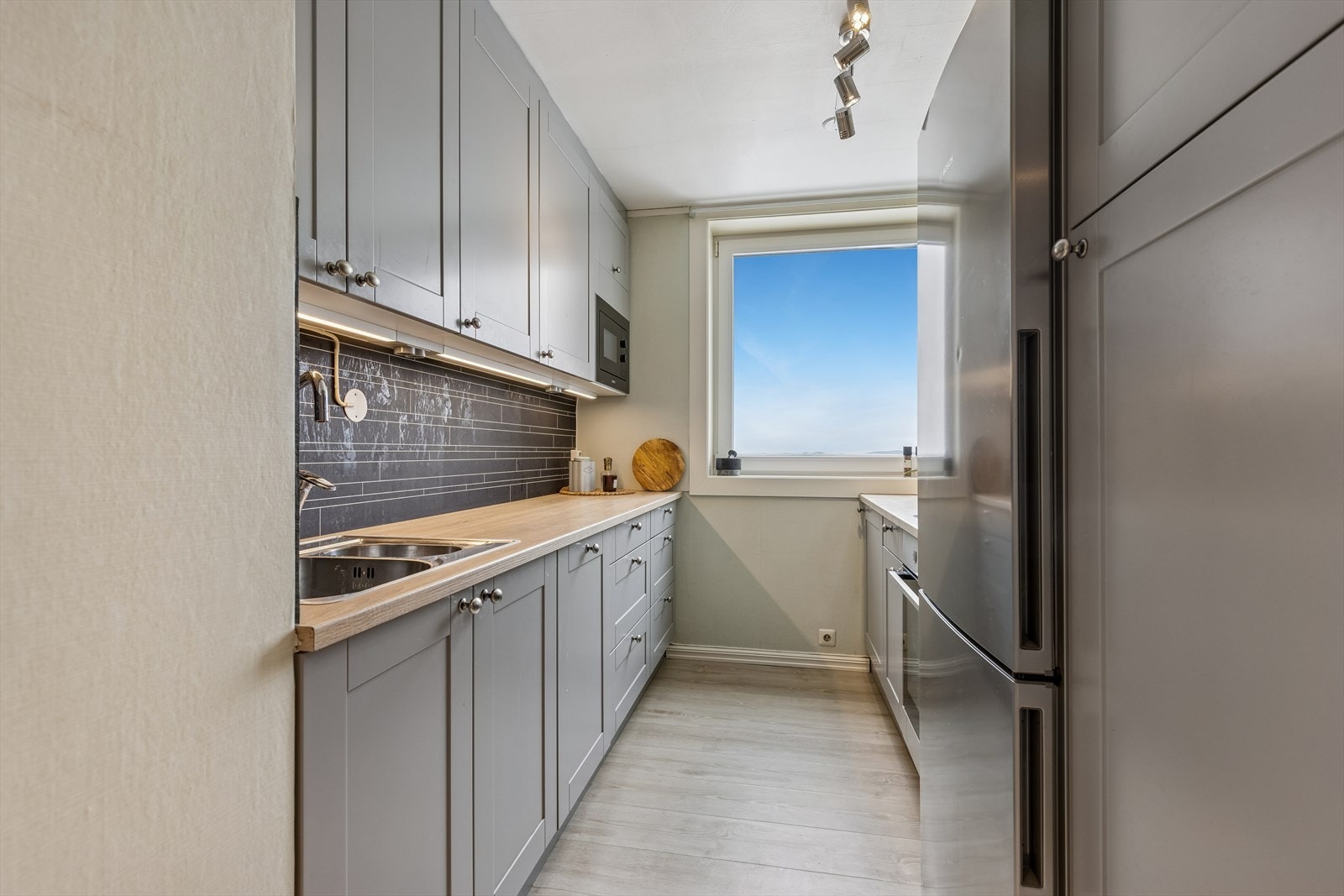 Kjøkkenet har en delikat innredning med grå glatte fronter. Galleribilde