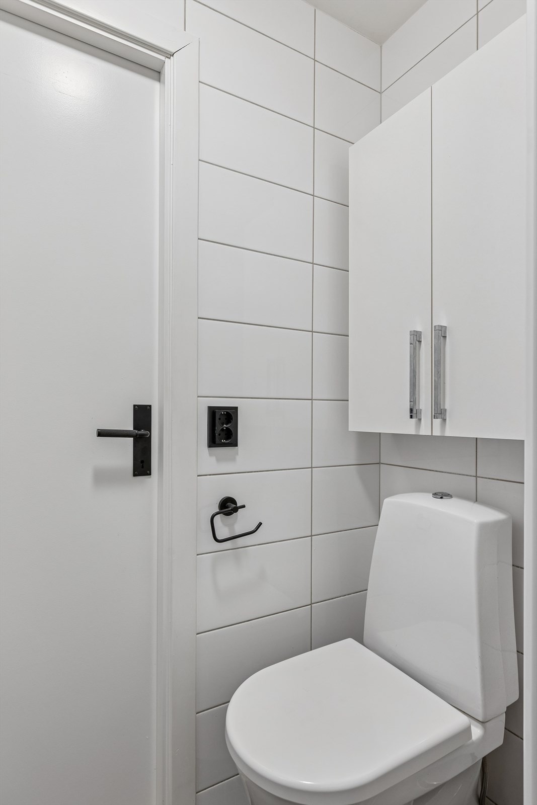 Leilighetens bad er helfliset, sorte detaljer går igjen på hele badet og skaper en moderne helhet. Galleribilde