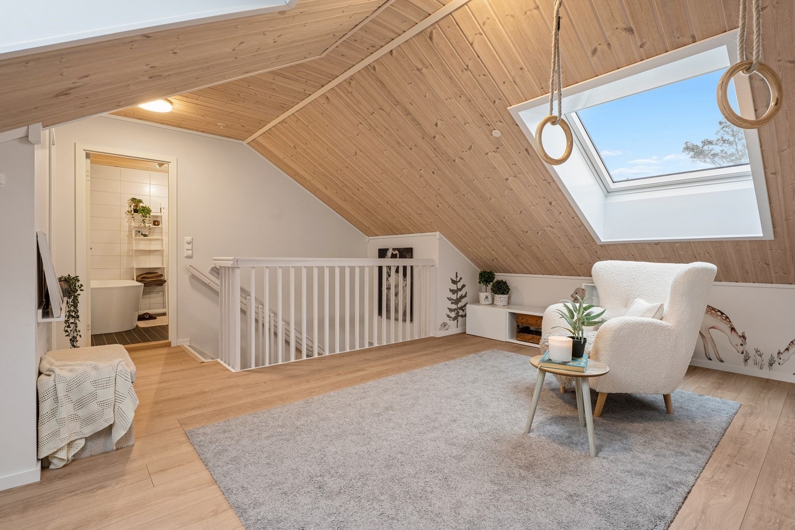 Lys loftstue som har god takhøyde og med god plass til å stor sofagruppe og oppholdsmøblement. Galleribilde