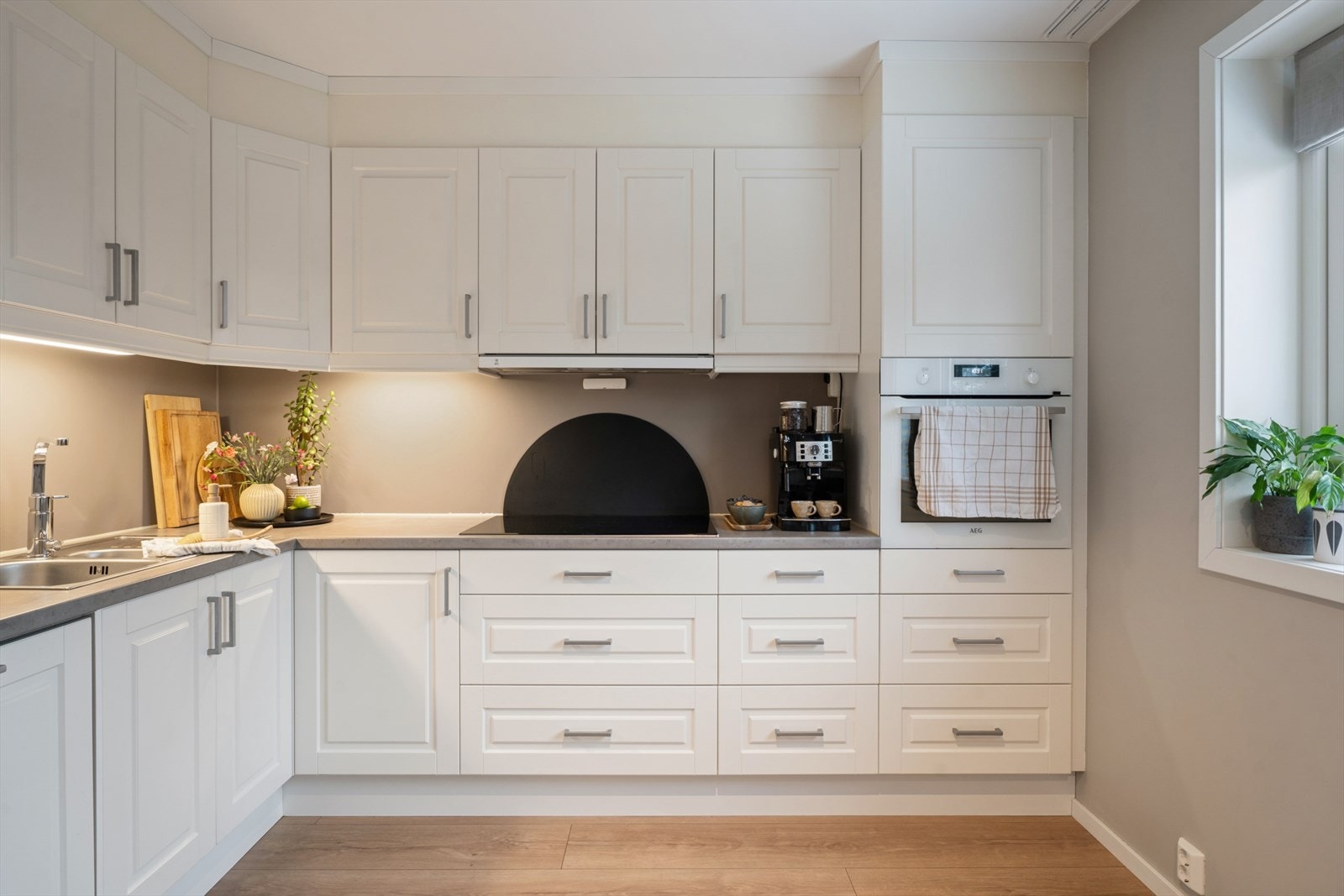 Kjøkkeninnredning fra byggeåret som har profilert fronter, laminat benkeplate, samt utslagsvask og blandebatteri. Galleribilde