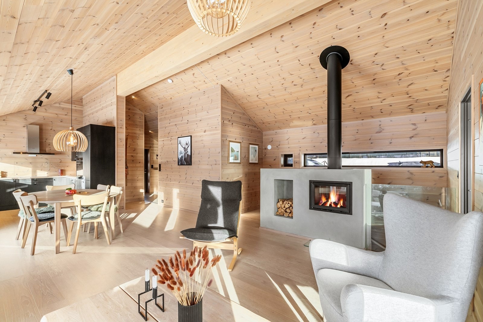 Glassrekkverk i pen kontrast. Peisen er med innsats og eget innhukk for ved. God plass for møblering i flere soner. Luftig, romslig og delikat. Galleribilde