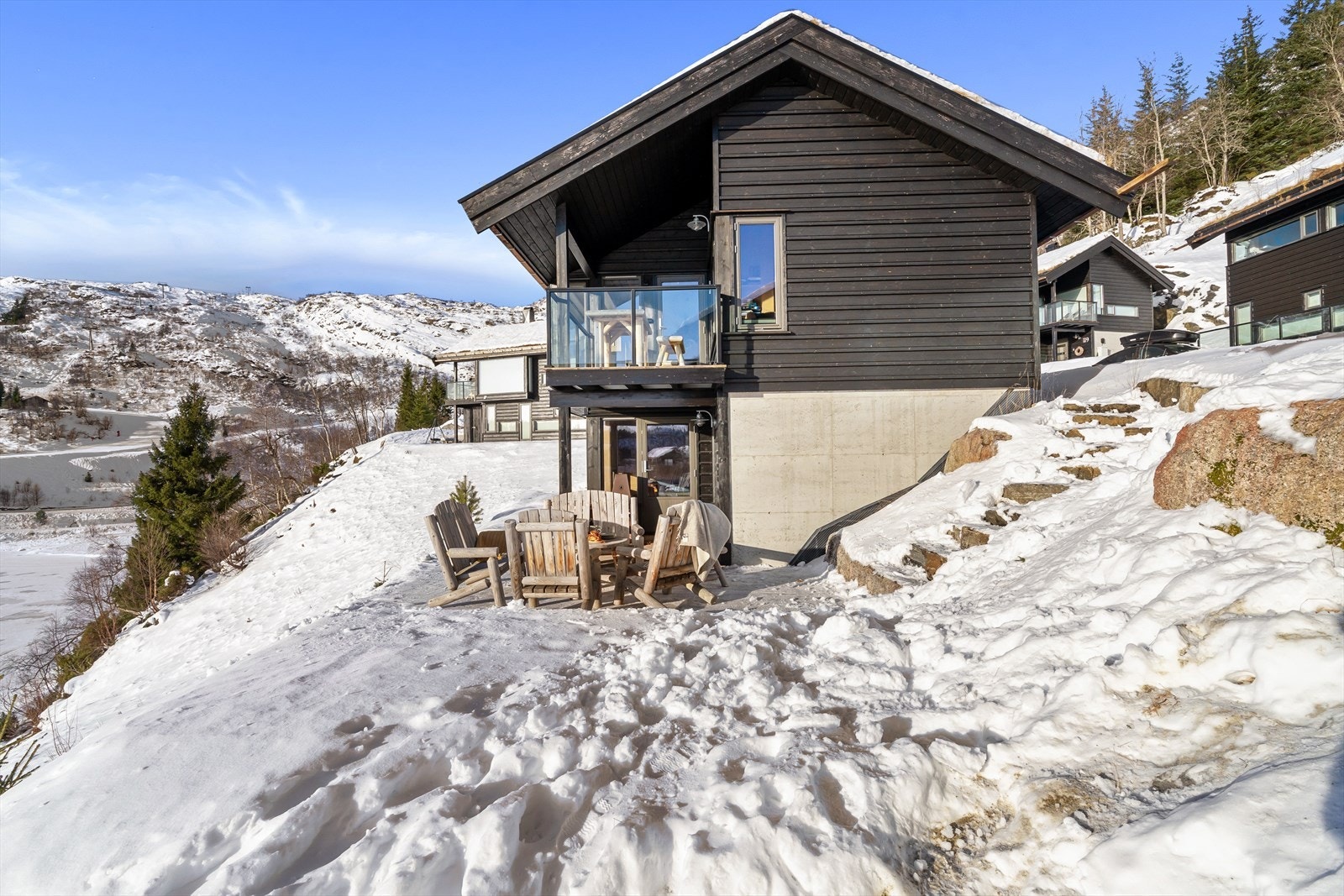 Steintrapp ned eller opp til hovedentre. Store uterom med nydelige solforhold og utsikt. Boltreplass for lek og morro. Akebakke ned til langrennsporet. Galleribilde