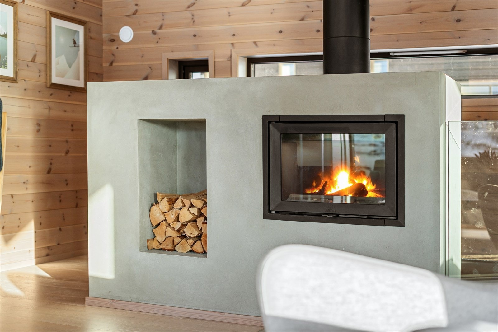 Moderne og flott peis med innsats og eget innhukk for ved. En pen kontrast til lunt tre, glassrekkverk og 1-stavs gulv. Her koser en seg. Galleribilde