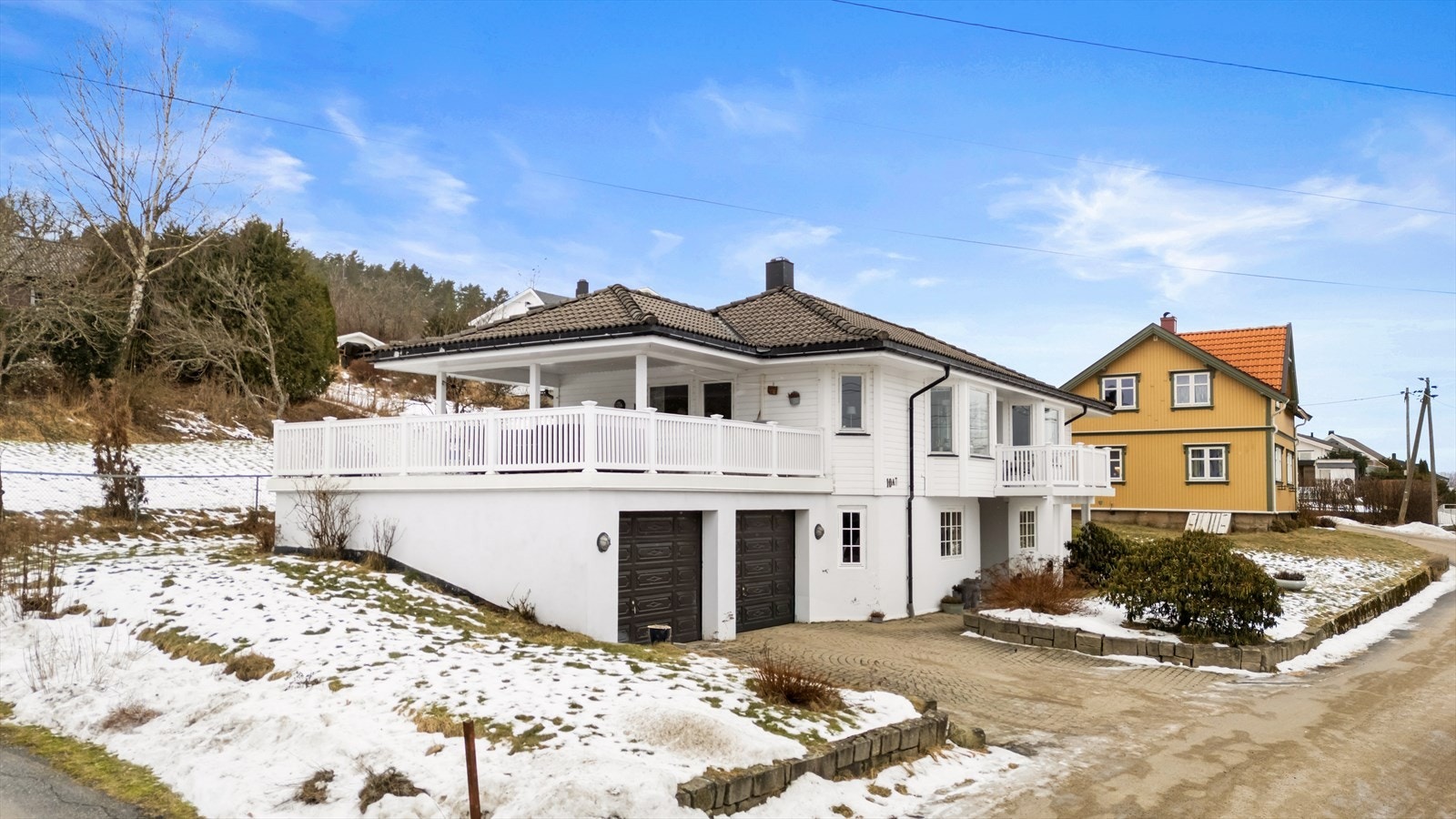 Boligen er omkranset av store uteplasser, inkludert en sørvendt terrasse på ca. 46 m² over garasjen. Galleribilde