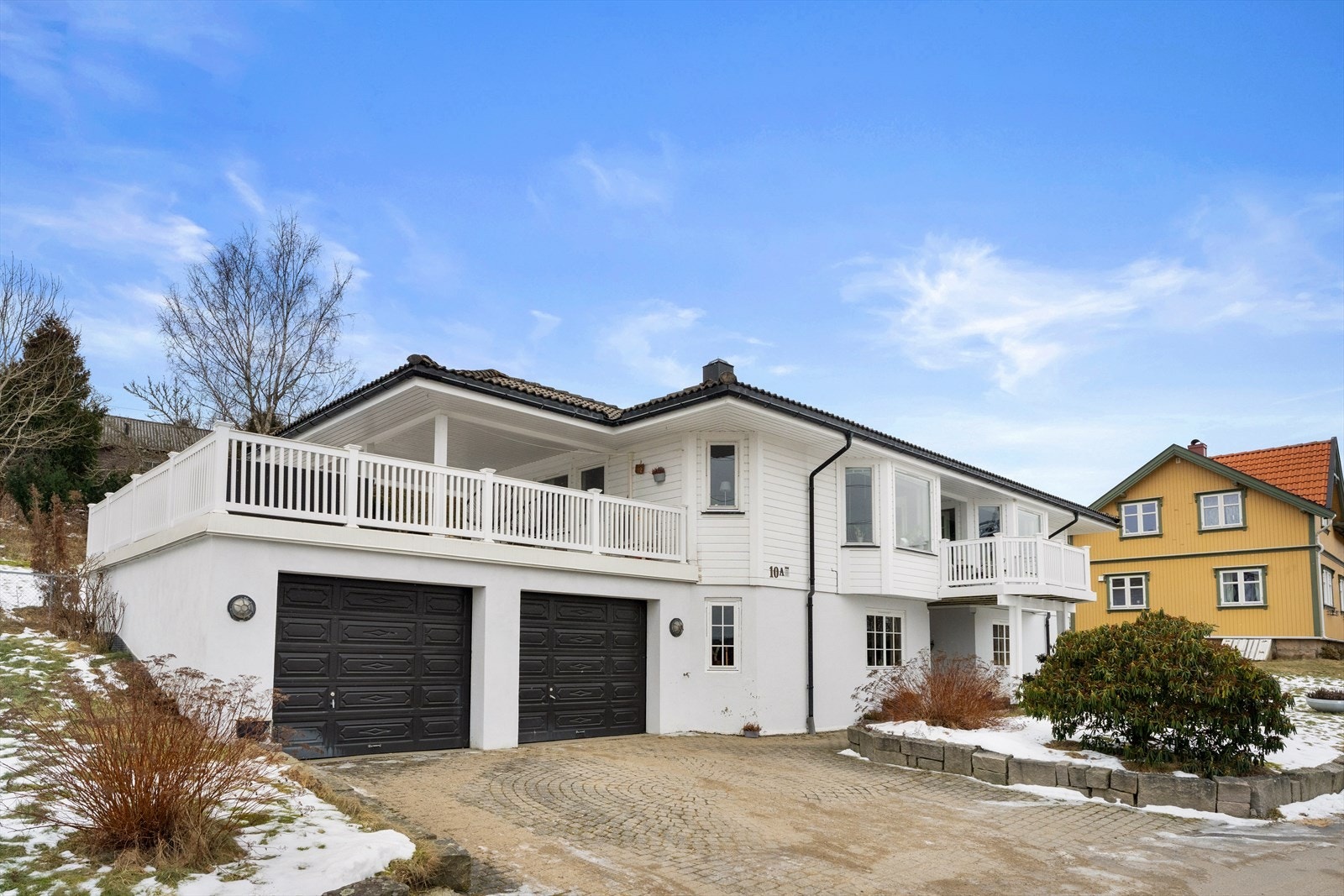 Eiendommen har en stor, dobbel garasje og en steinsatt gårdsplass med plass til ytterligere to biler. Galleribilde