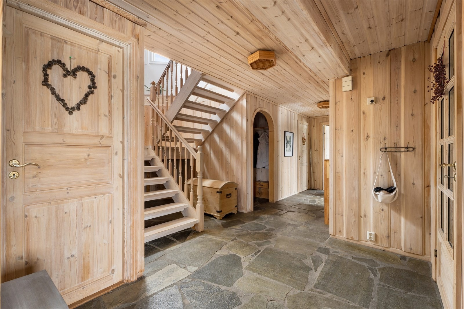 Gangen i underetasjen har gjennomgående skifergulv og en solid tretrapp opp til hovedetasjen. Galleribilde