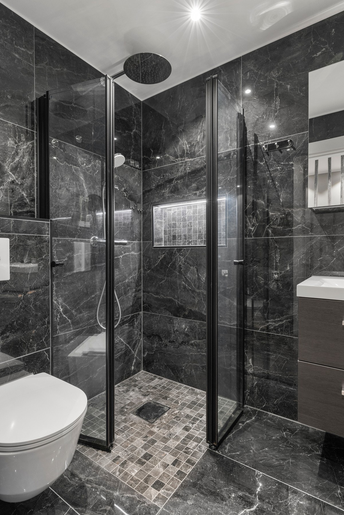 Rommet er utstyrt med veggmontert toalett, servant og dusjhjørne, samt opplegg for både vaskemaskin og tørketrommel Galleribilde