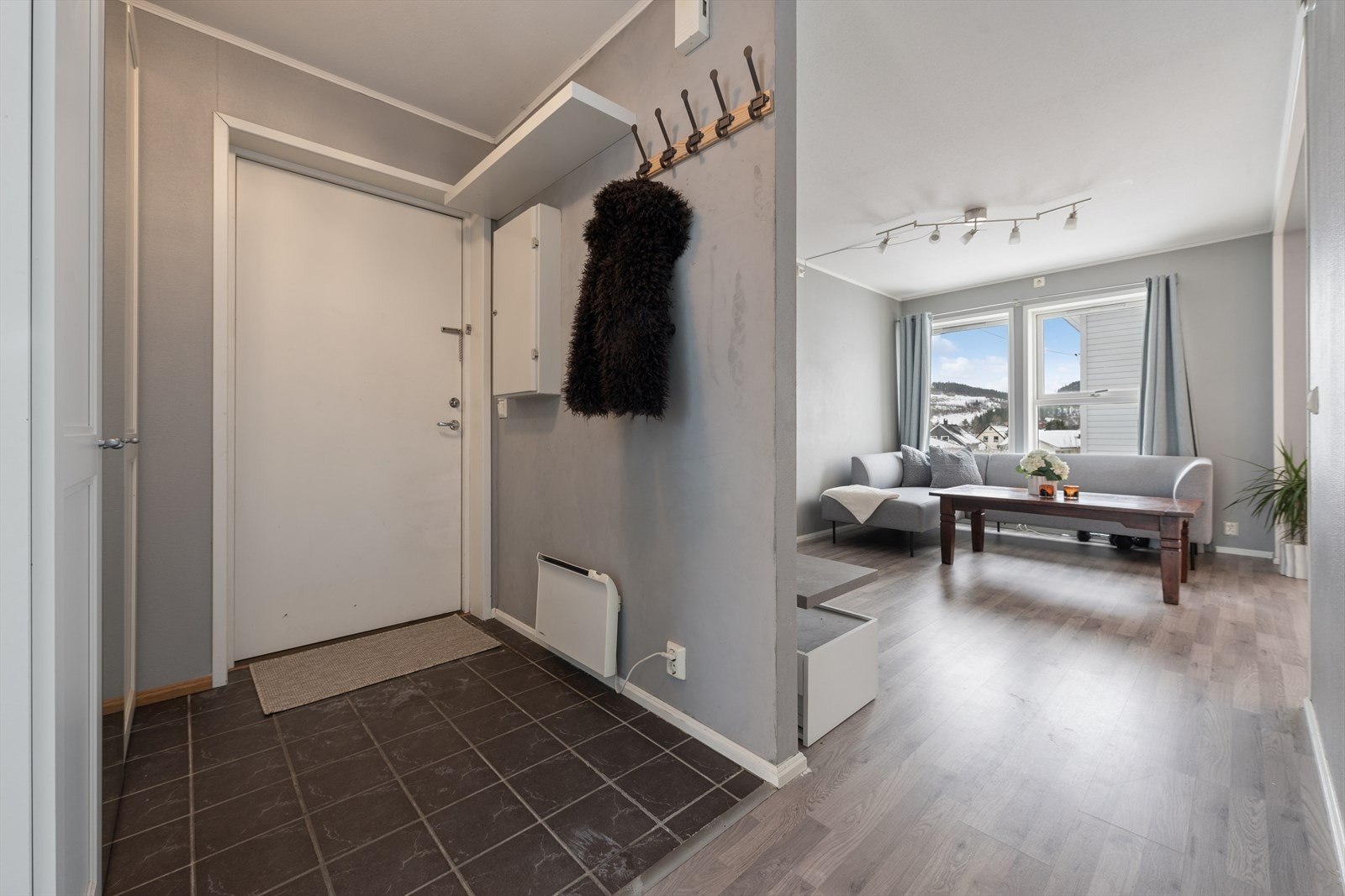 Velkommen inn i en praktisk entré med flislagt gulv og stort garderobeskap til å henge fra seg. Galleribilde