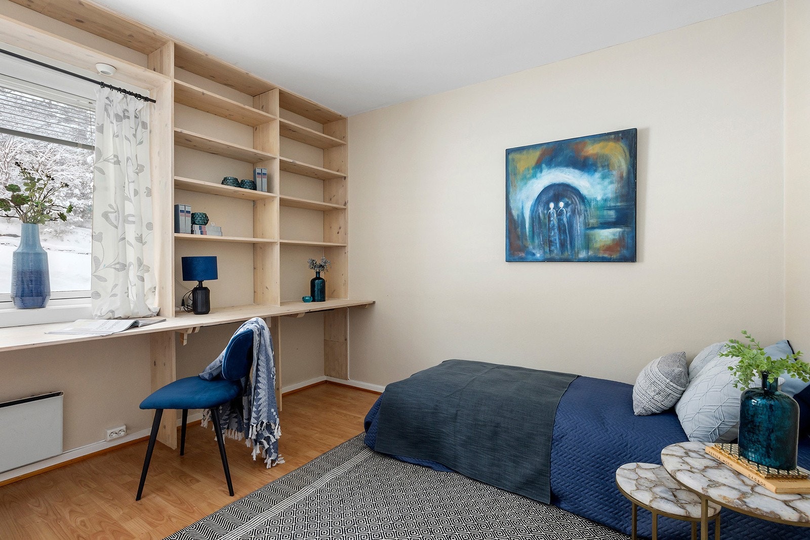 Romslig soverom med praktisk kombinert hylle-og skrivebordløsning. Galleribilde