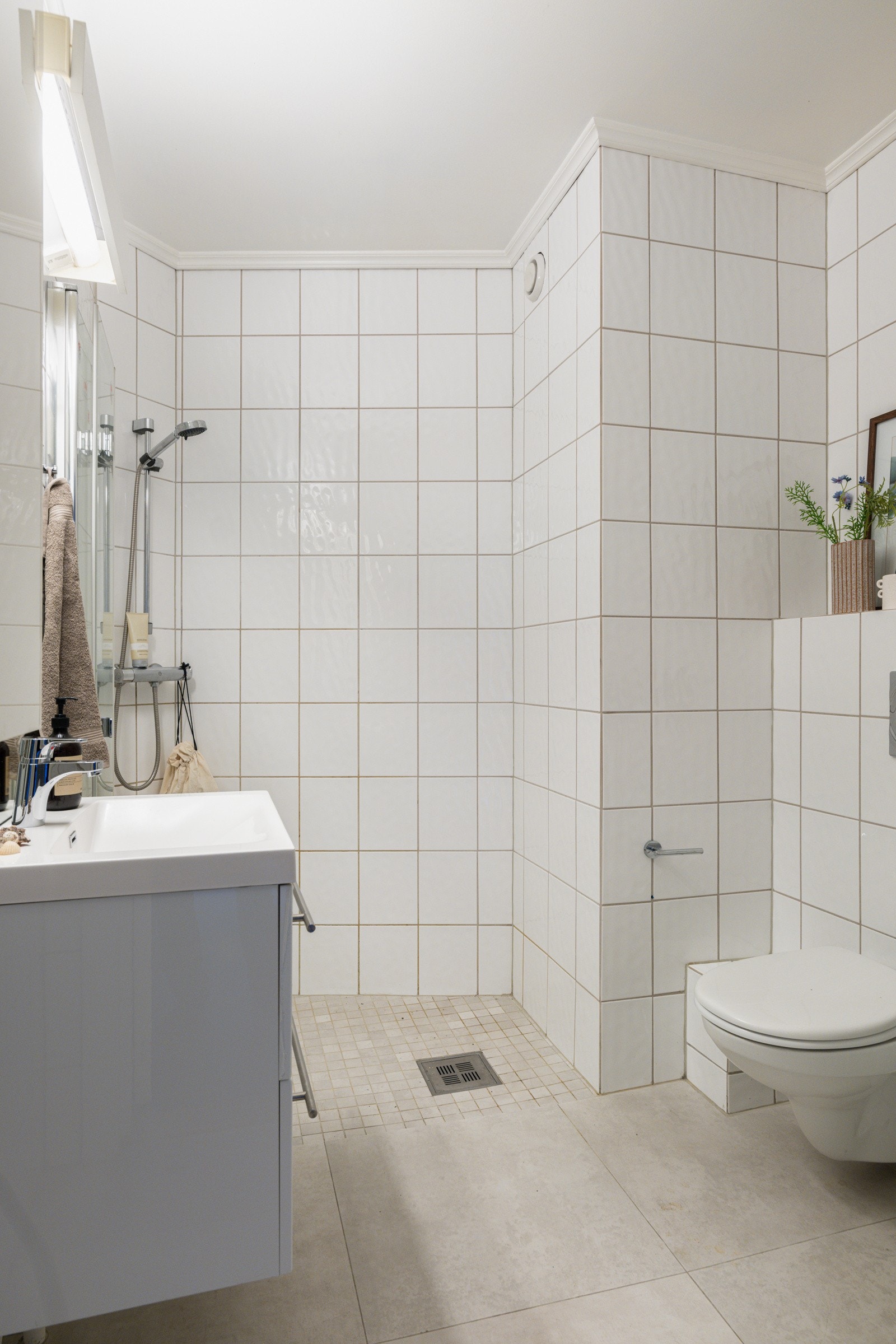 Leiligheten har et lyst flislagt baderom som ble overflatebehandlet i 2020. Galleribilde