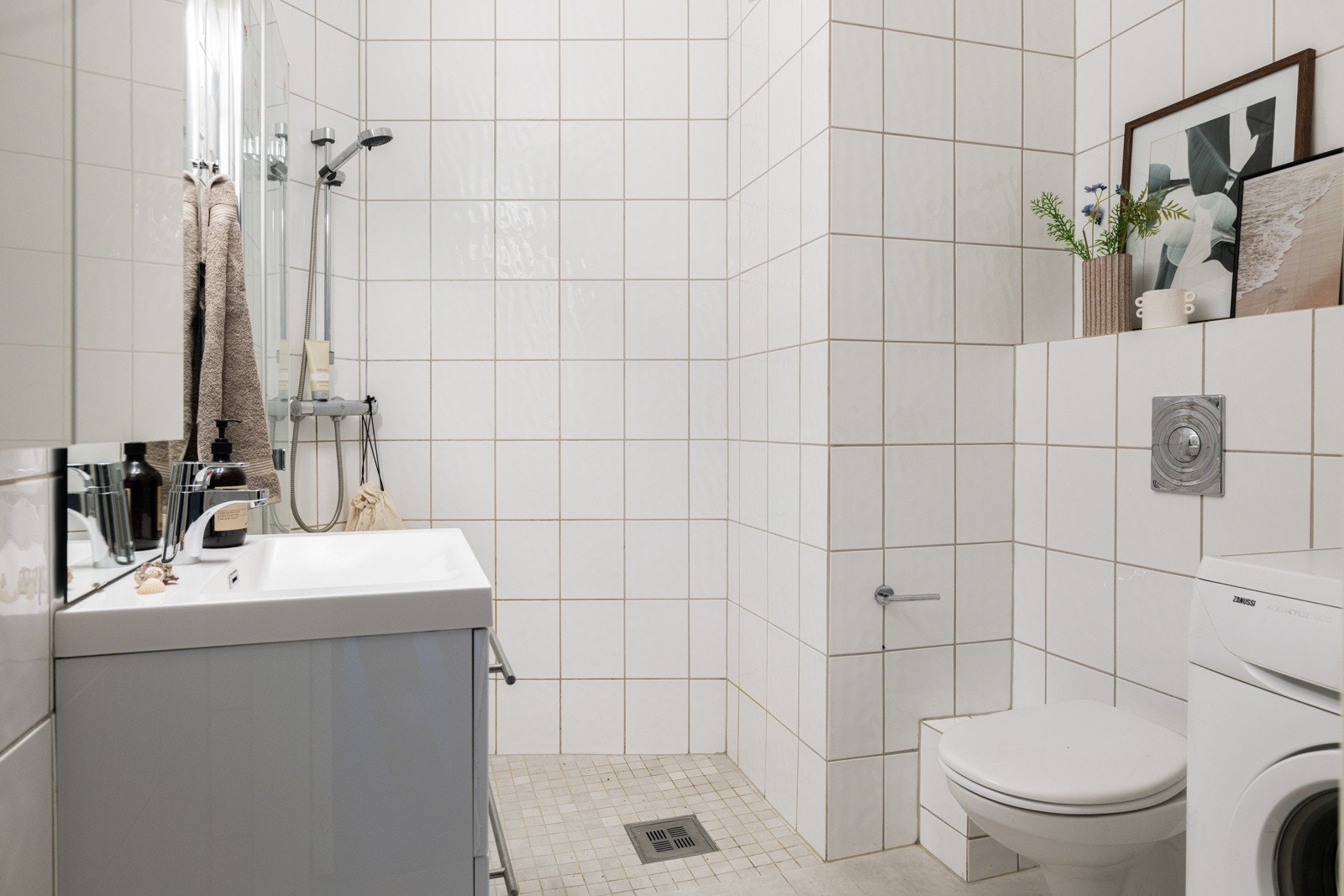 Baderommet har moderne fliser på gulv, elektriske varmekabler, hvite fliser på veggene og mekanisk avtrekk. Galleribilde