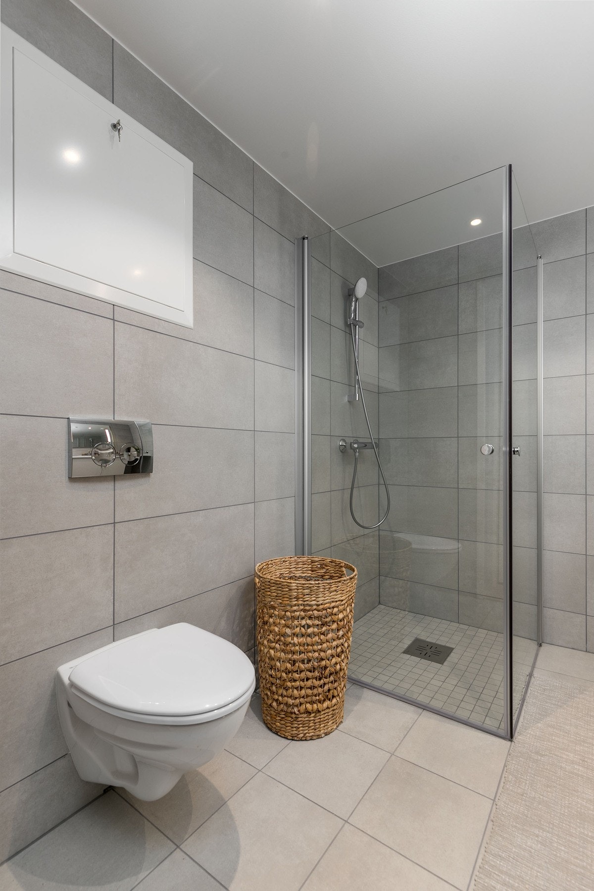 Badet har vegghengt toalett med innbygget sisterne, servant med skapinnredning samt speil med belysning. Galleribilde