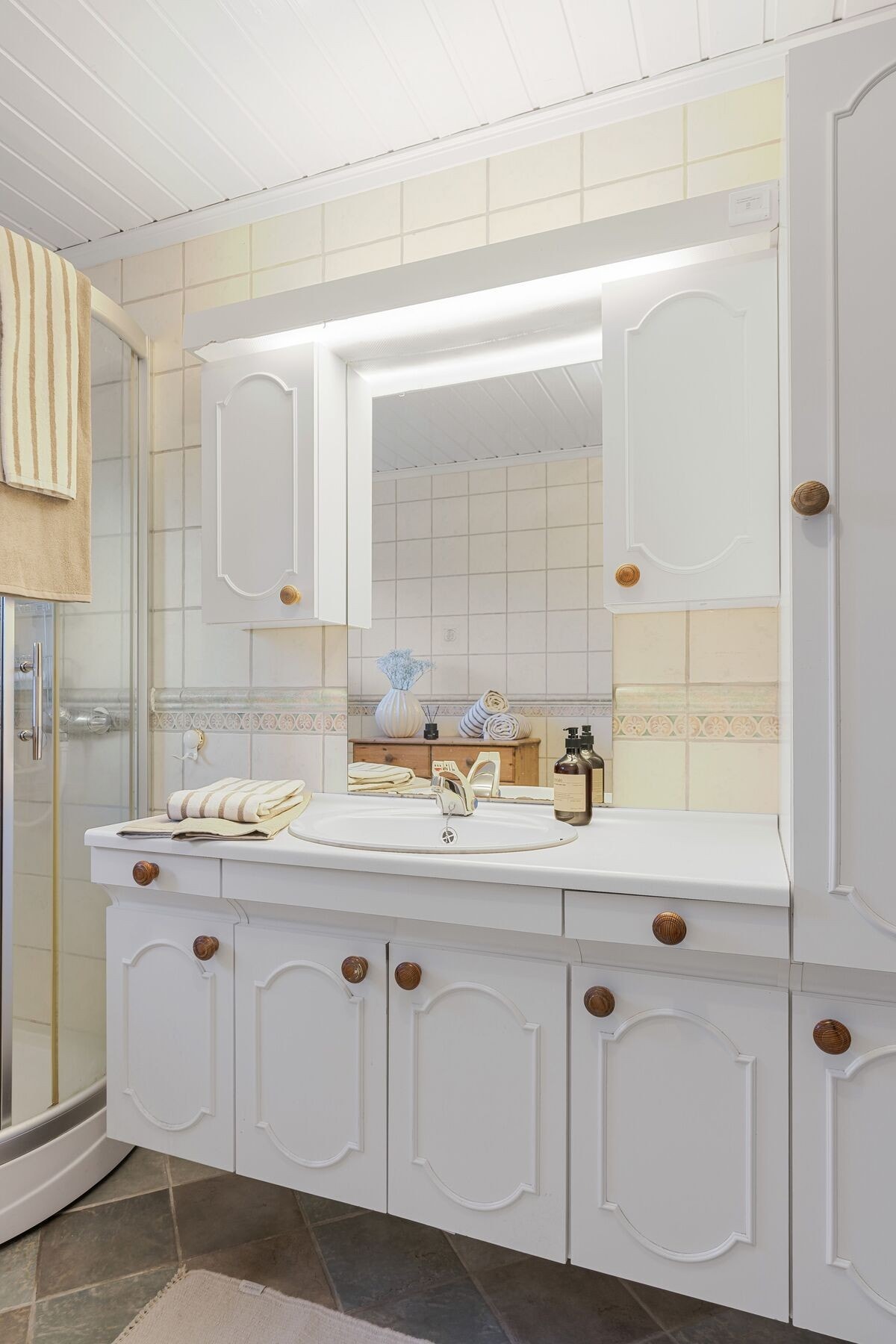 Badet er utstyrt med baderomsinnredning, dusjkabinett og toalett Galleribilde