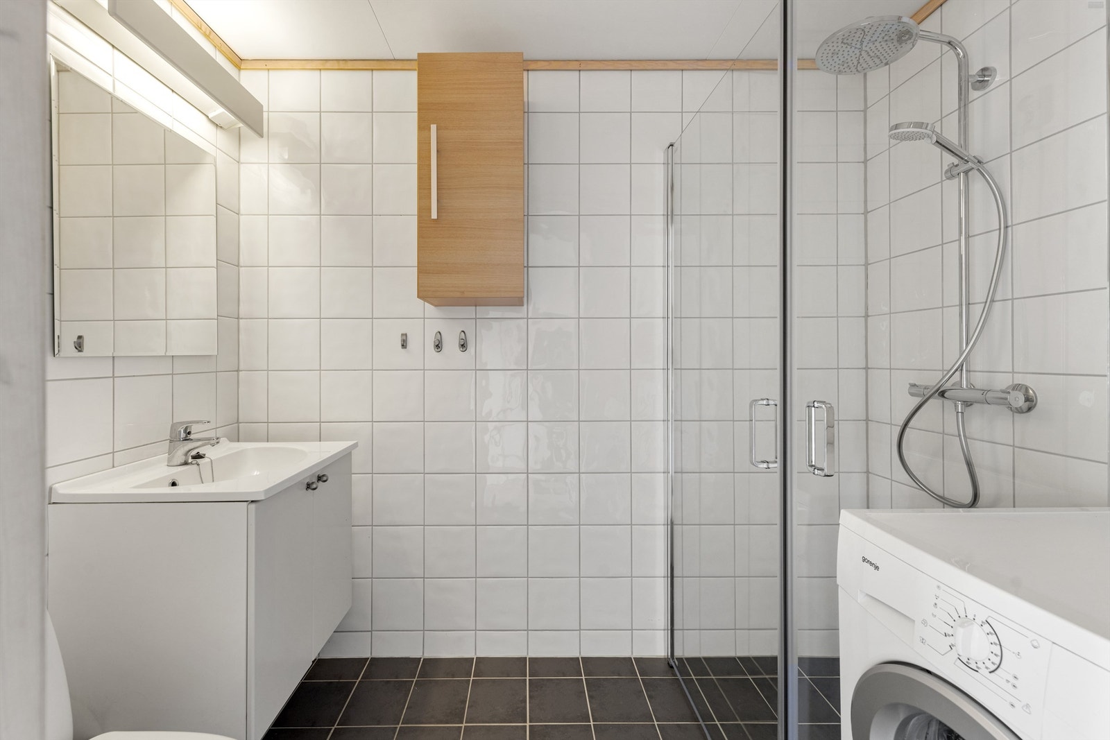 Praktisk bad med dusj, toalett og servant. Det medfølger vaskemaskin. Galleribilde