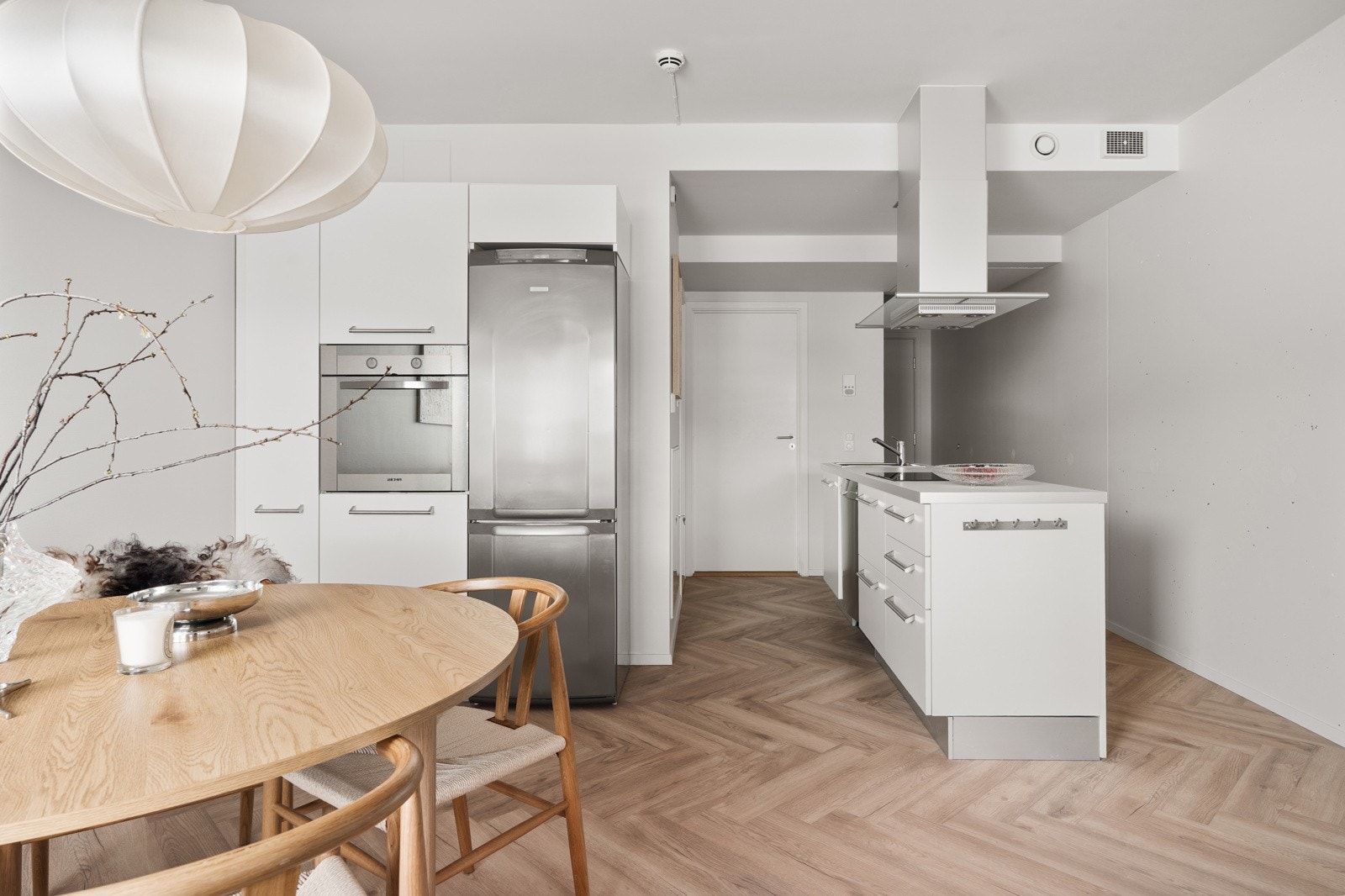 Lekre detaljer som fiskebeinsmønster på gulv og et ellers industrielt, skandinavisk preg.