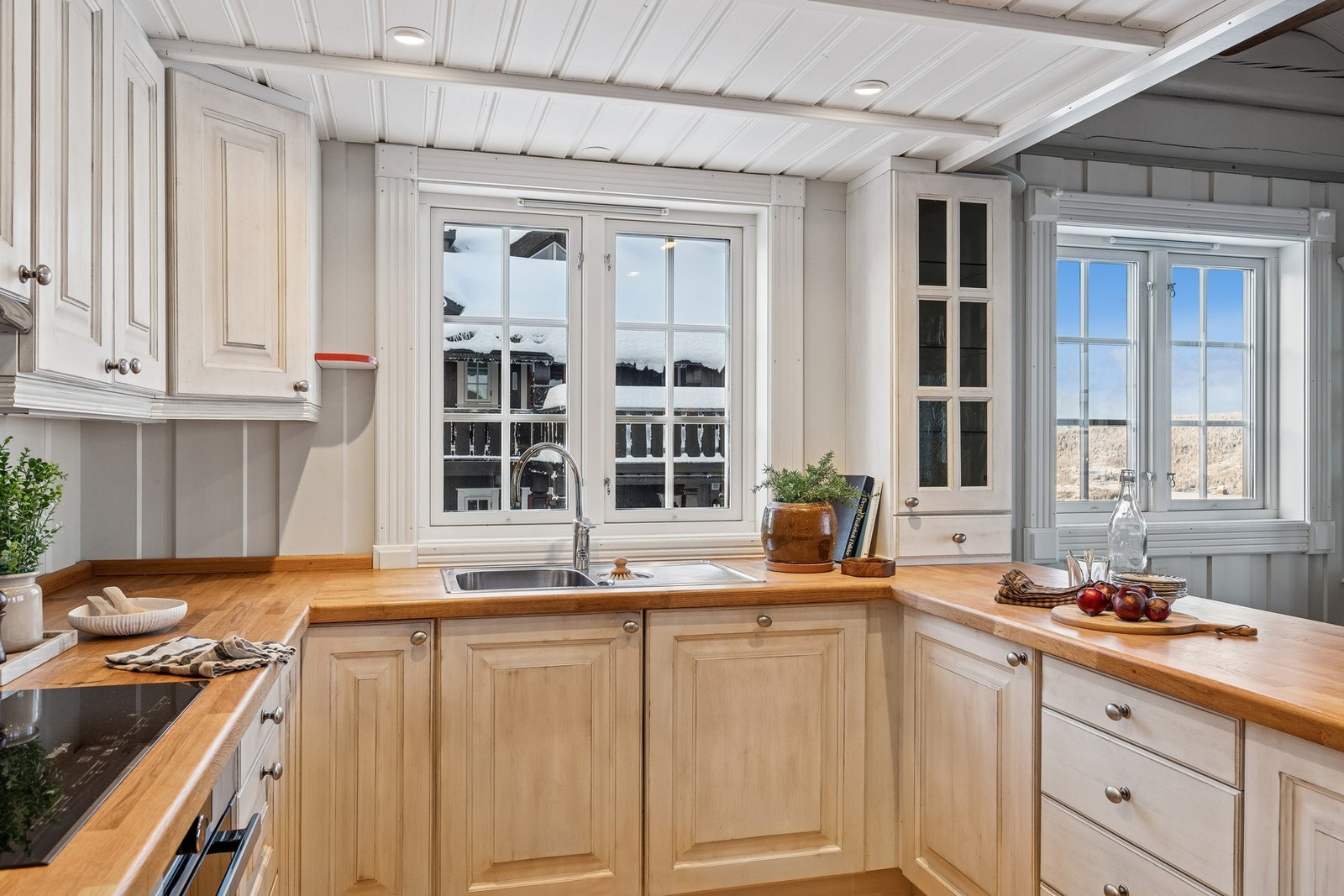 Kjøkkeninnredningen er i heltre med profilerte fronter, malt i en lys fargetone, og byr på rikelig skapplass. Galleribilde