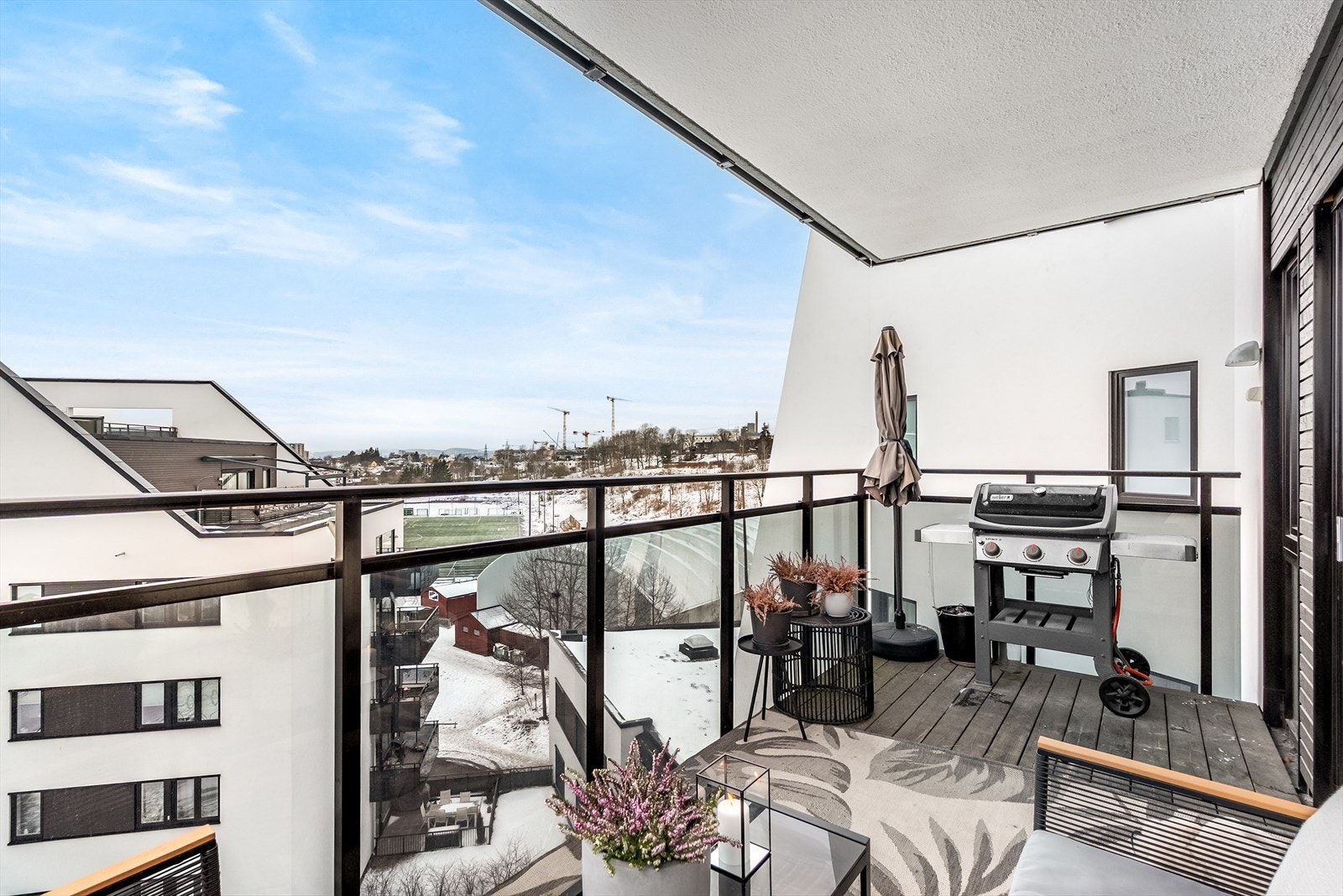 Balkongen har også utebelysning, strømuttak og god plass til grill. Utsikt mot Lørenbanen og horisonten mot vest. Galleribilde