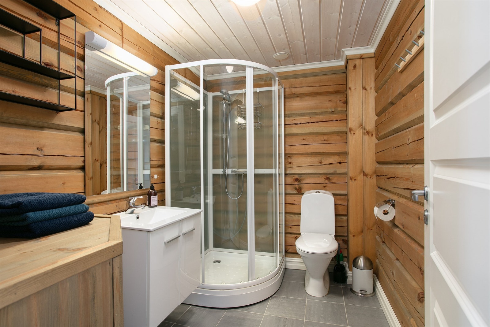 Bad med flislagt gulv med gulvvarme, tømmervegger og panel i tak. Galleribilde