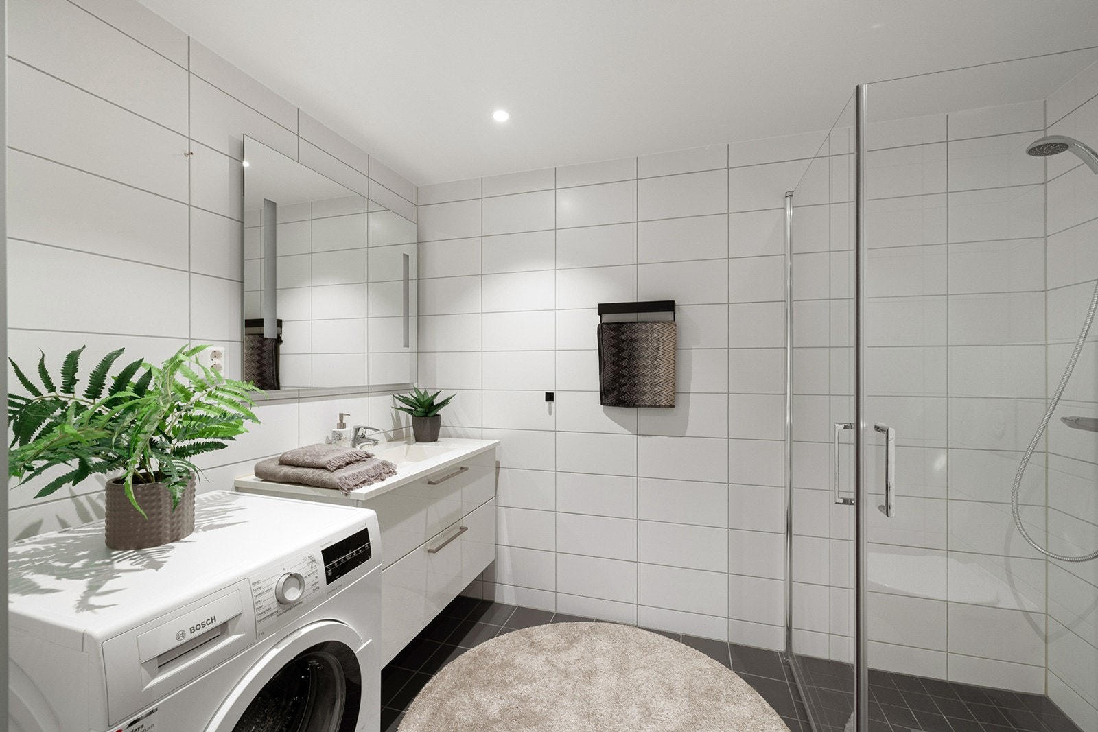 Pent og moderne flislagt bad med behagelig gulvvarme og downlights i himling. Galleribilde