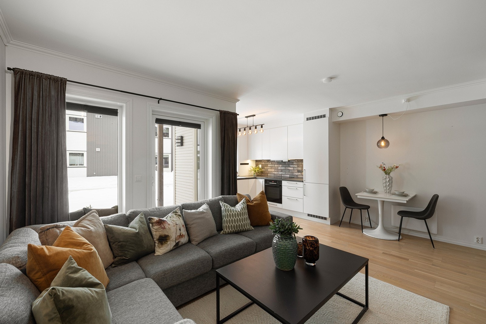 Lys og innbydende stue i åpen løsning mot kjøkken, som gir en luftig og sosial planløsning. Galleribilde