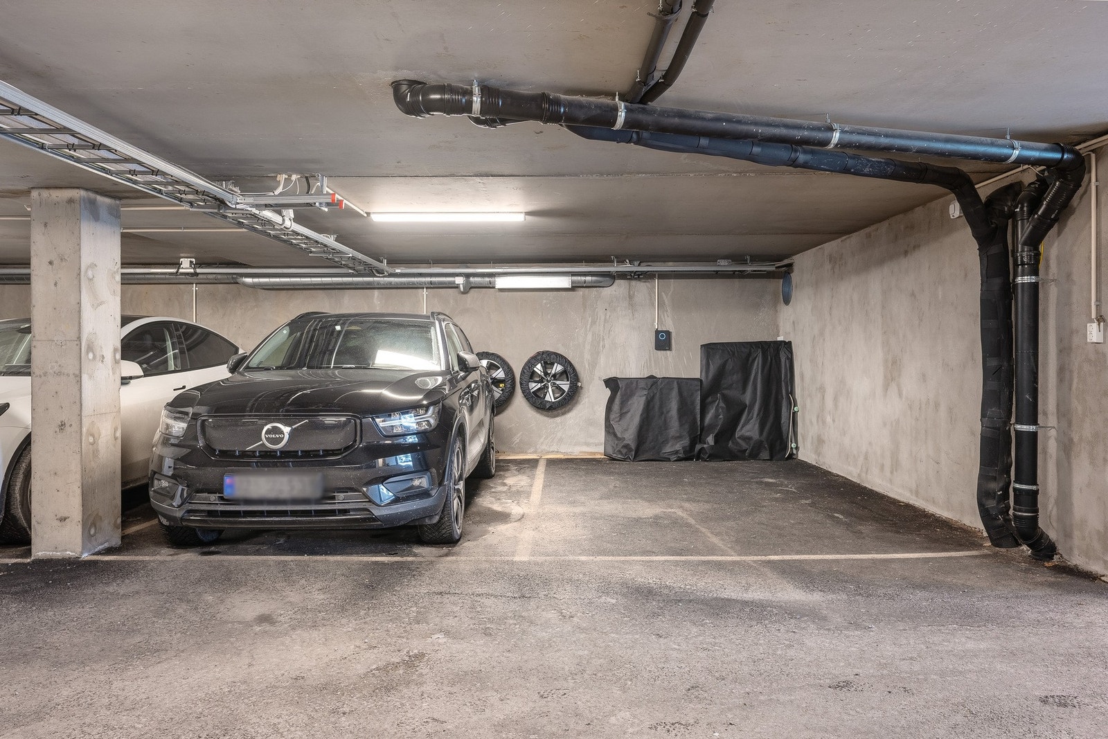 Boligen disponerer to parkeringsplasser i felles garasjeanlegg, begge med elbillader. Garasjeanlegget er etablert under ett av husene på tunet. Galleribilde