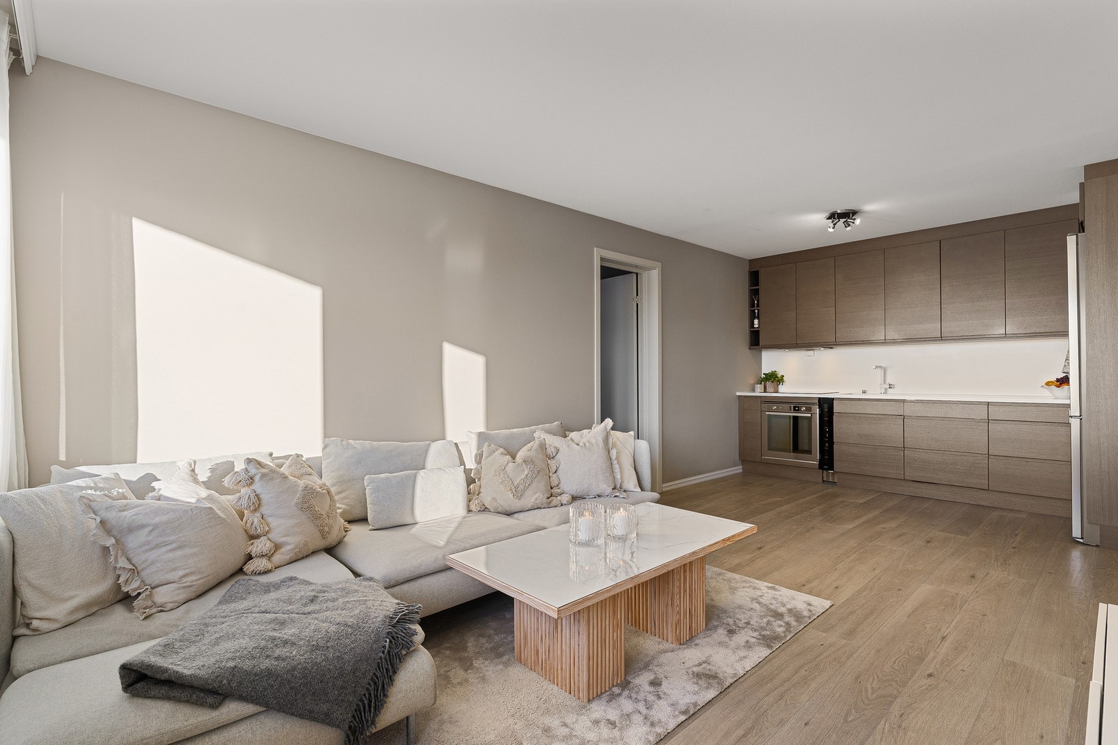 Lys og åpen stue-/kjøkkenløsning med plass til både sofa og spisebord. Galleribilde