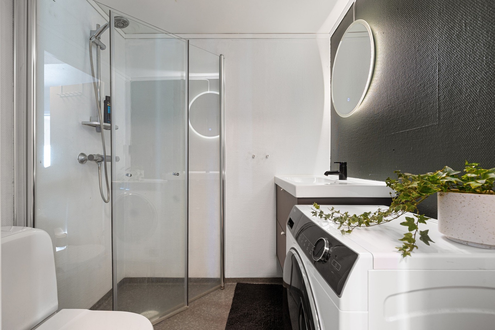 Badet har lun gulvvarme og innfellbare, plassbesparende dusjdører samt opplegg for vaskemaskin. Galleribilde