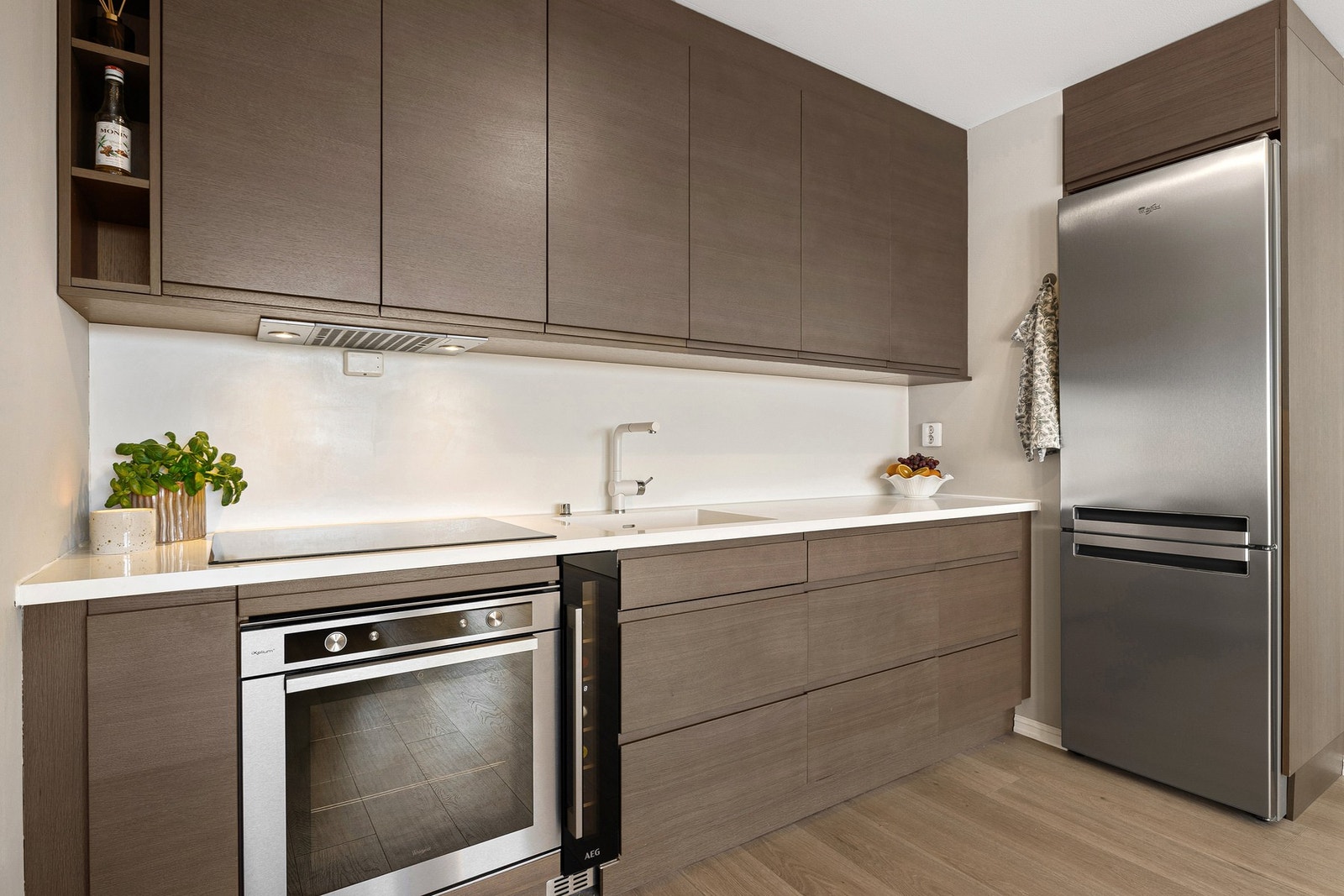 Kjøkkeninnredningen er smakfull med benkeplate i kompositt og tidsriktige kjøkkenfronter. Galleribilde