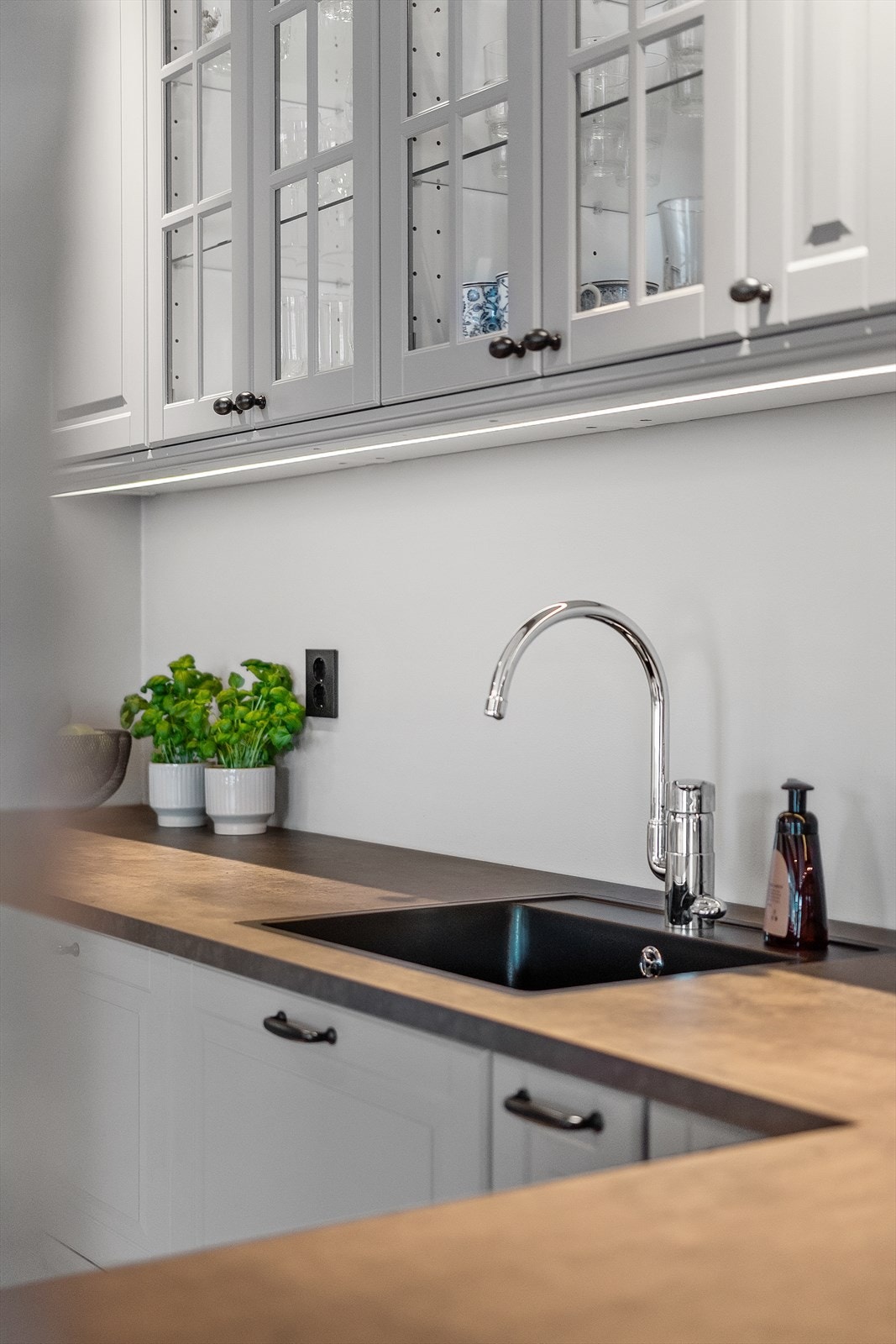 Nedfelt vask i benkeplaten og integrert LED-belysning under overskapene sørger for både god funksjonalitet, lekkert utseende og stemningsfullt lys. Galleribilde