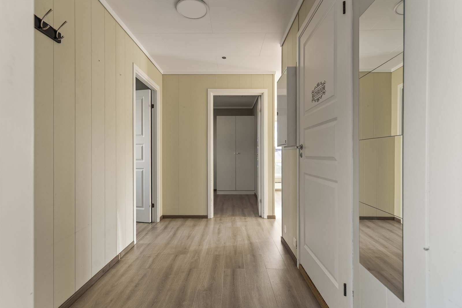 Entréen har laminatgulv og malte panelplater, med god plass til oppbevaring i tilknyttede rom. Galleribilde