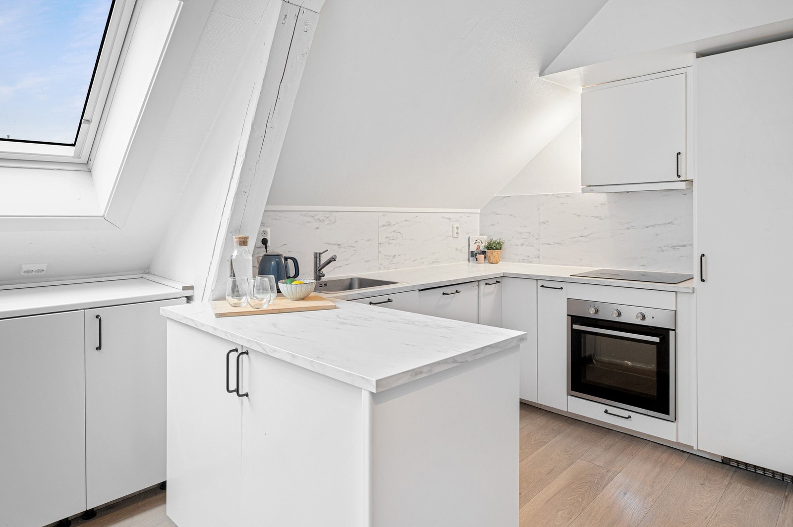 Kjøkkenet har innredning med glatte fronter. Benkeplaten er av laminat. Galleribilde