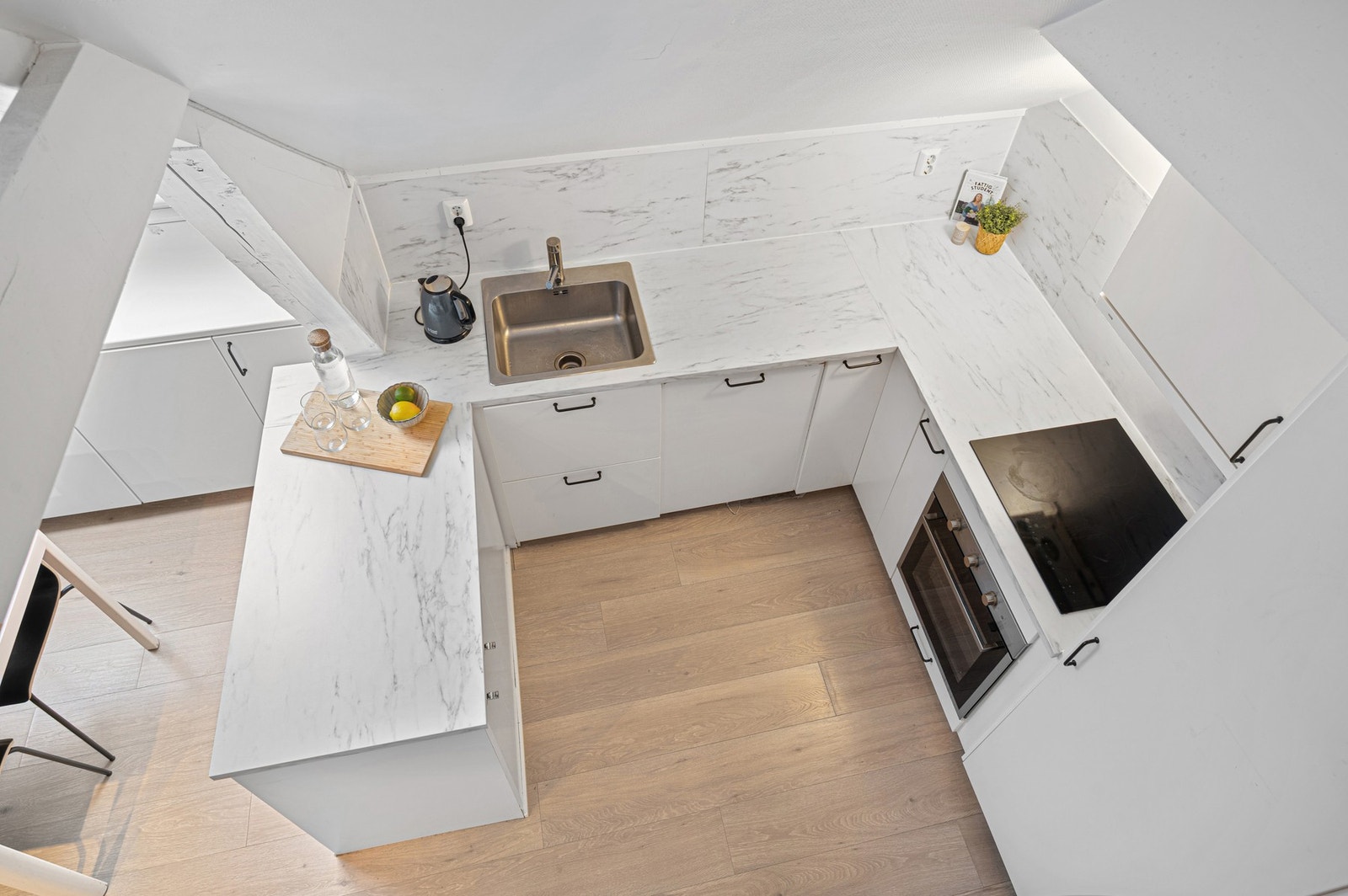 Praktisk og stilrent kjøkken sett fra loft. Kjøkkenet ble oppusset i 2020 og har fått TG1 av takstmann. Galleribilde