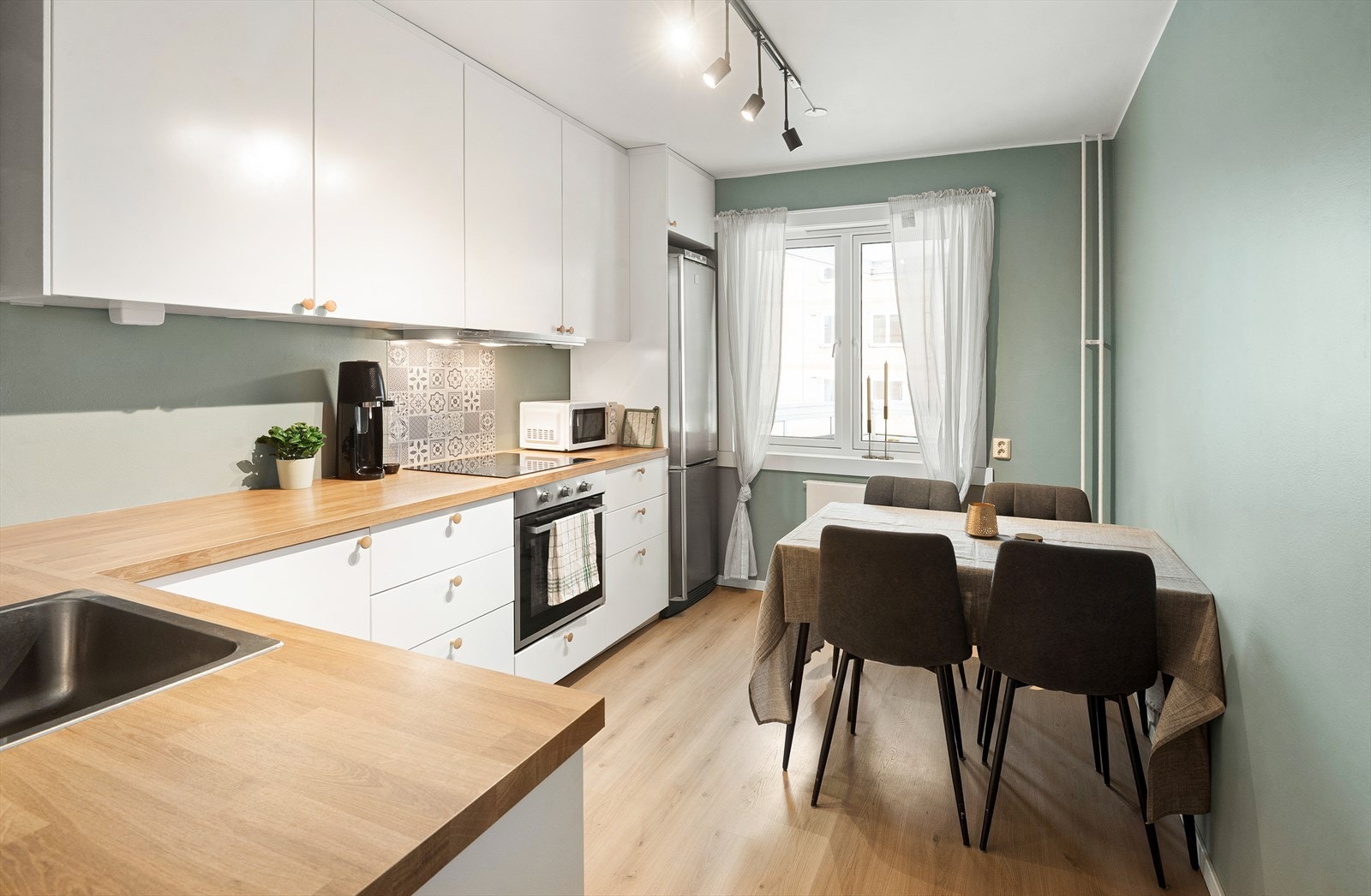 Stilrent kjøkken fra 2022 med glatte fronter og benkeplate i laminat. Galleribilde