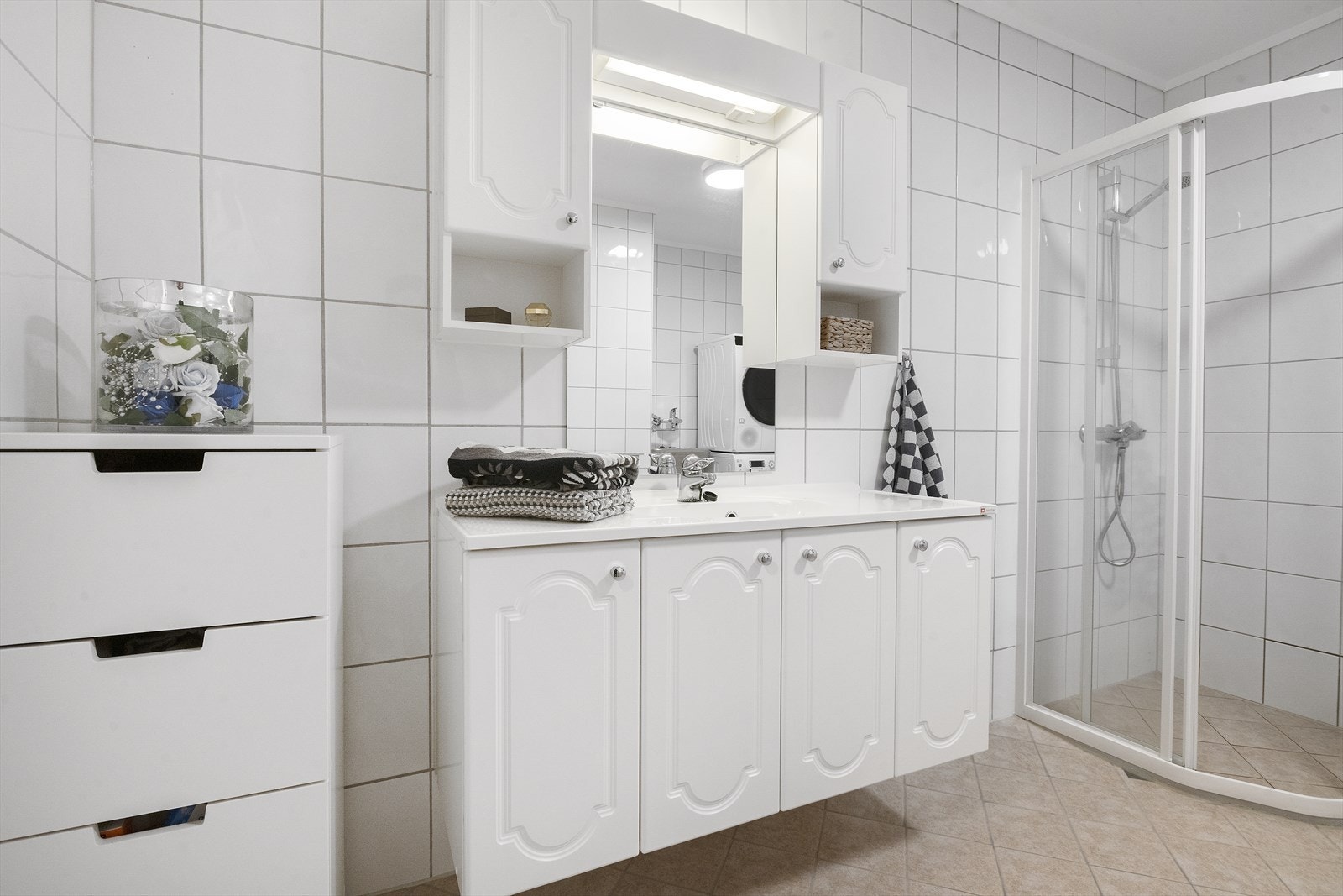 Romsleg bad innreidd med servant i underskap, overskap, dusjhjørne og eiga nisje med opplegg for vaskemaskin og utslagsvask Galleribilde