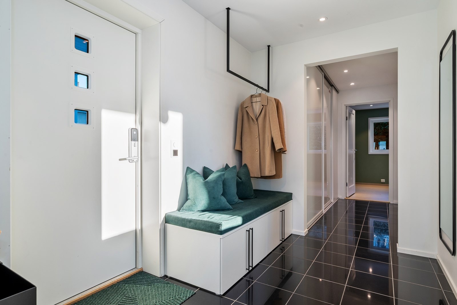 36. Romslig entré med flislagt gulv og skyvedørsgarderobe gir et godt førsteinntrykk. Ytterdør med kodelås og appstyring gir både sikkerhet og brukervennlighet. Galleribilde