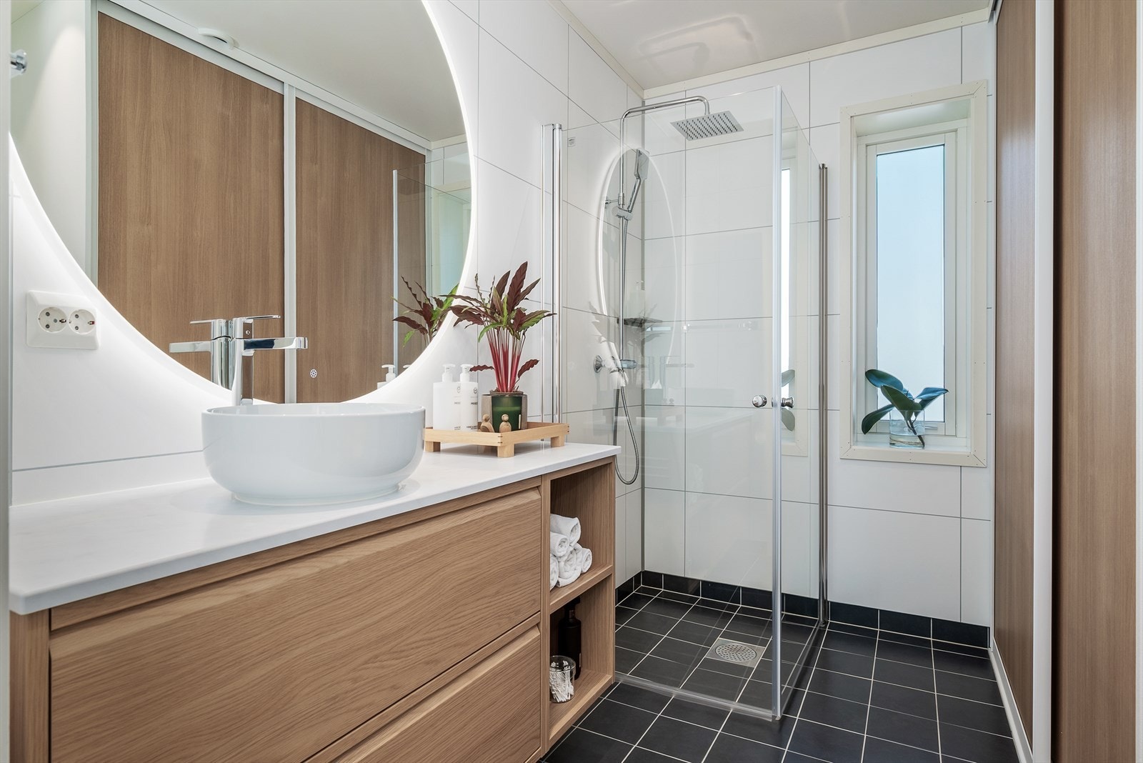 Badet i 1.etg er 6,5 kvm og byr på en praktisk løsning med Elfa skyvedørsgarderobe, som skjuler vaskemaskin/tørketrommel på en smart måte. Galleribilde