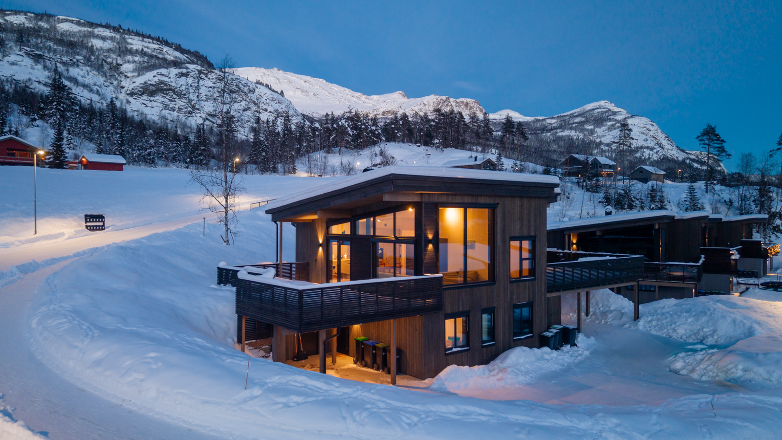 Opplev magien i blåtimen fra denne moderne boligen med store vindusflater som rammer inn fjellandskapet. Galleribilde
