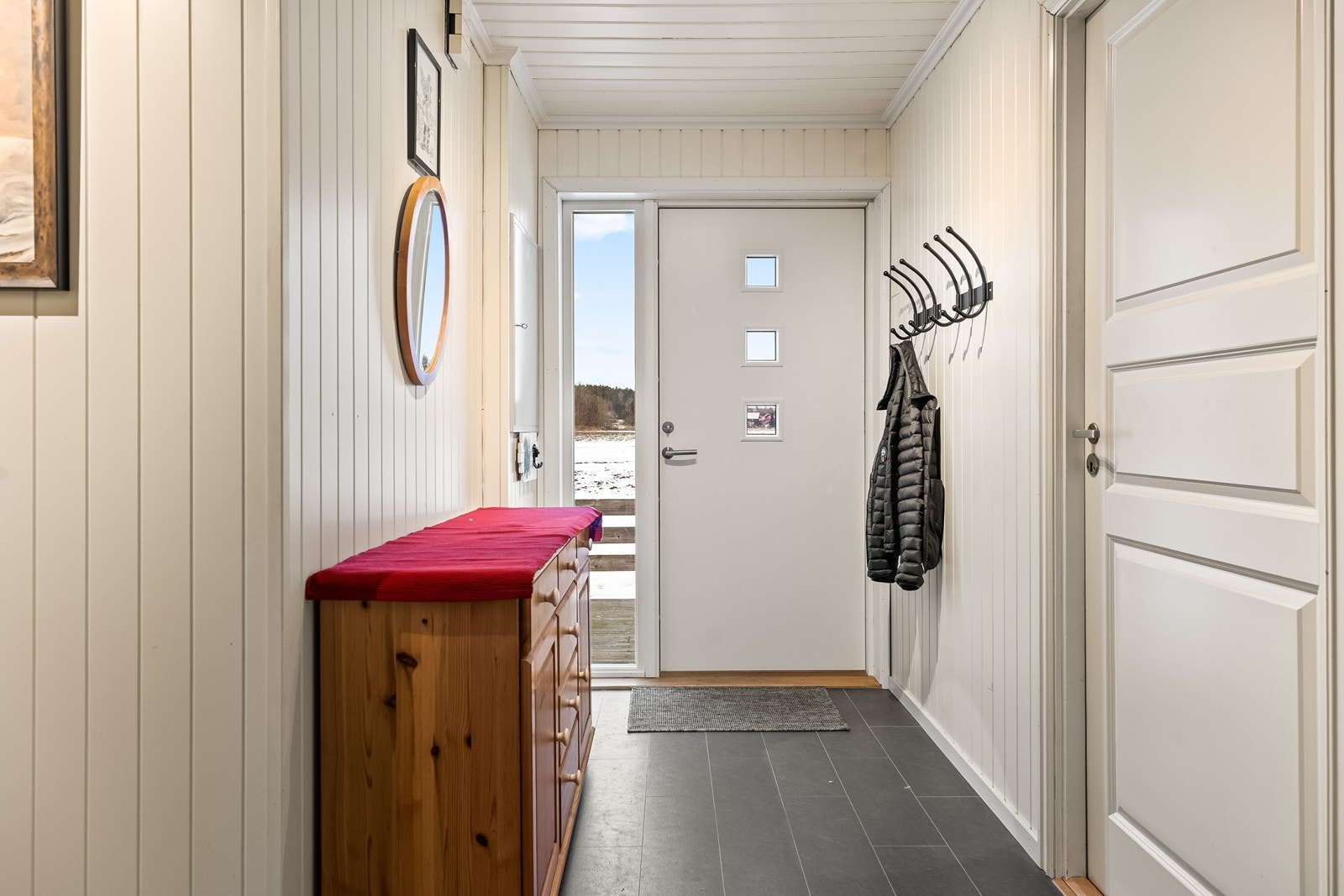 Velkommen inn i en lys entré med flislagt gulv og plass til yttertøy. Galleribilde